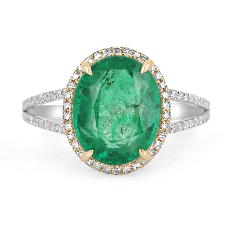 14K Colombian Emerald and diamond halo engagement ring with oval emerald center and split shank design.