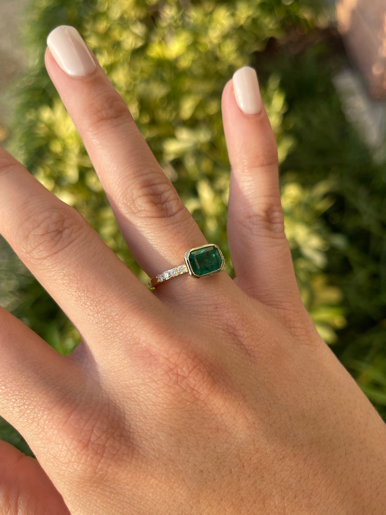 Colombian Emerald 14K gold ring with natural emerald cut emerald, bezel setting, and diamond shank, showcasing elegant craftsmanship.