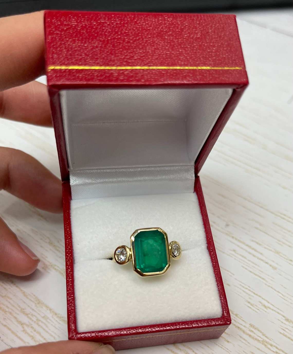 classic emerald and diamond bezel ring with dark green stones