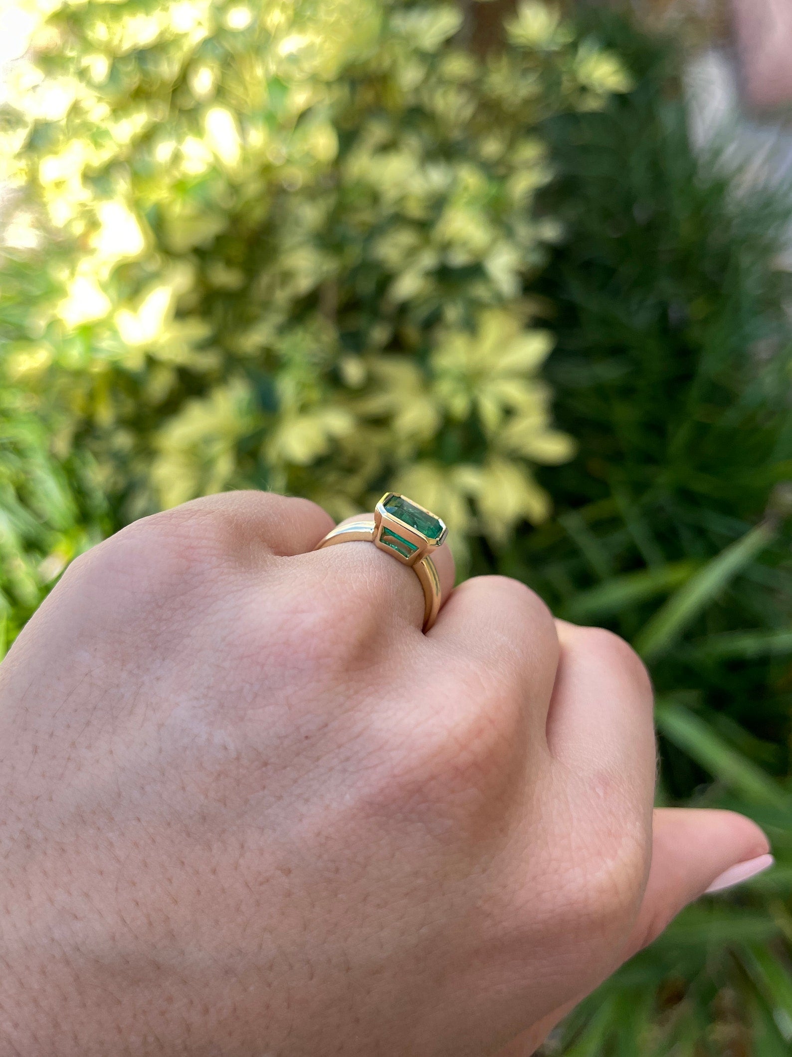 Dark vivid green emerald bezel solitaire ring featuring a 2.75ct east-to-west cut, set in 18K gold by JR Colombian Emeralds.