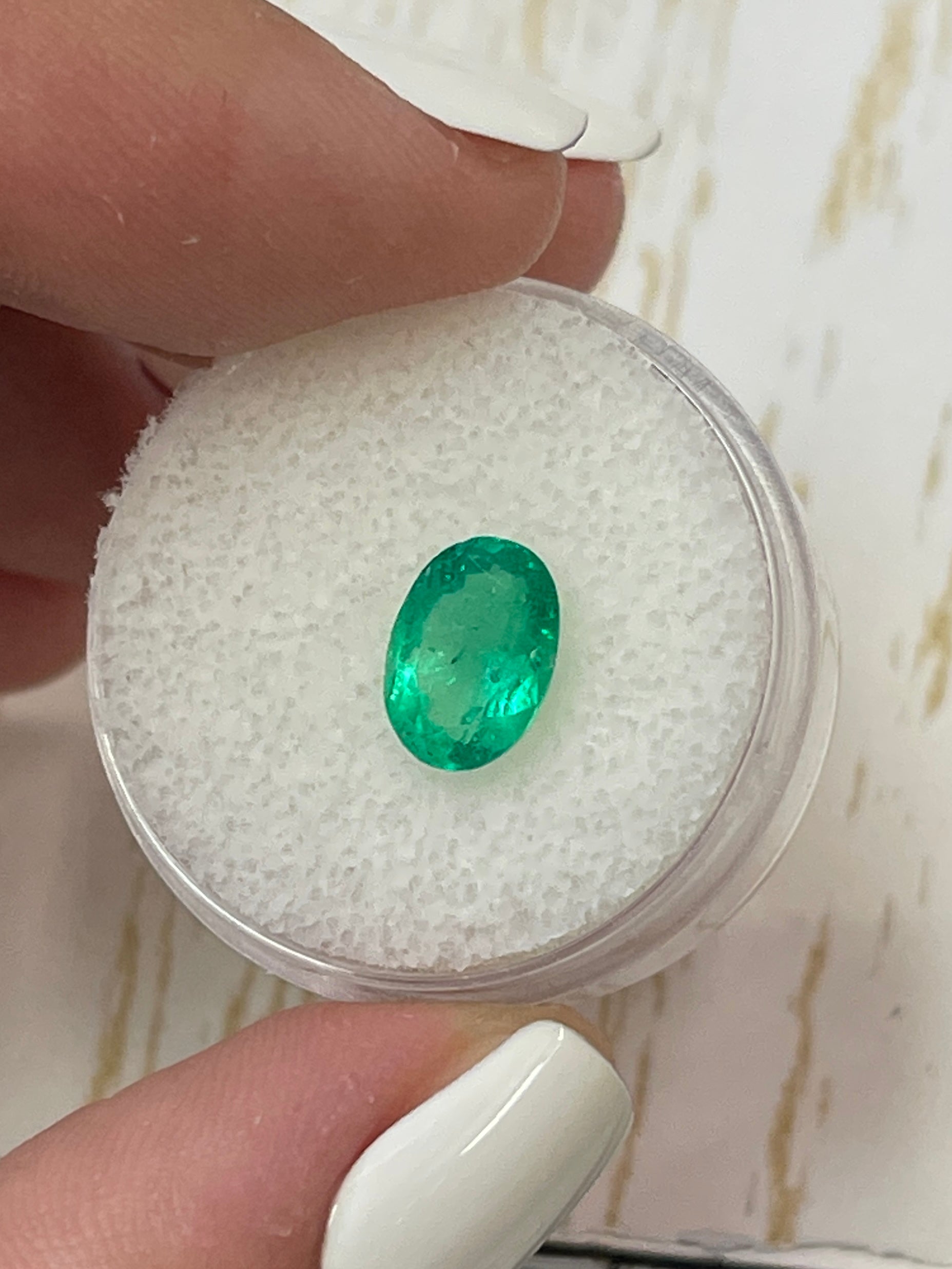 Oval cut 1.69 carat yellowish green Colombian emerald loose gemstone from JR Colombian Emeralds, showcasing vibrant color and clarity.