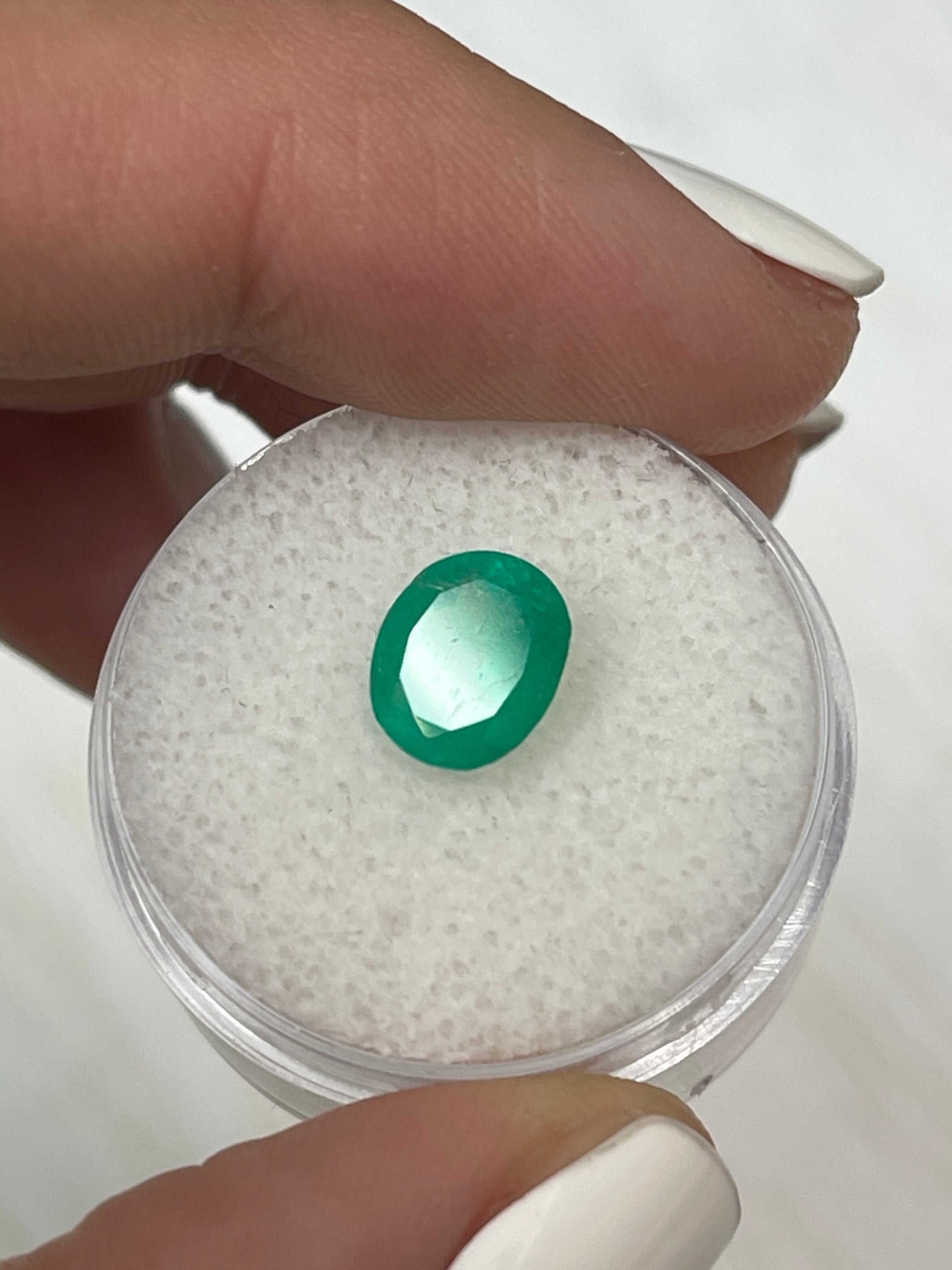 Loose 1.76 carat oval-cut Colombian emerald from JR Colombian Emeralds, vibrant medium green, natural gemstone with chunky shape.