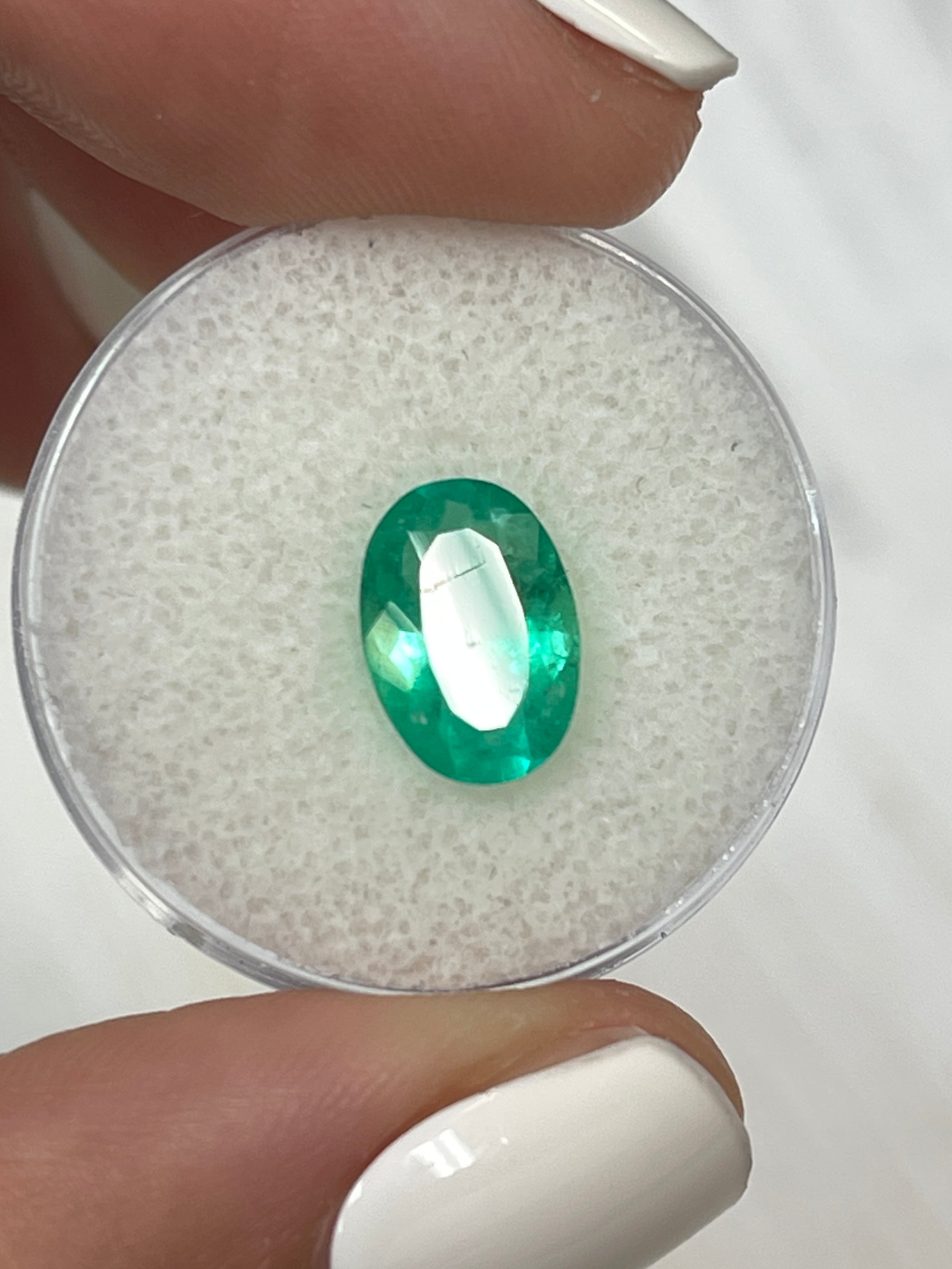 Elongated 11x8 mm Colombian Emerald loose gemstone with 1.96 carats, vivid apple green color, oval cut from JR Colombian Emeralds.