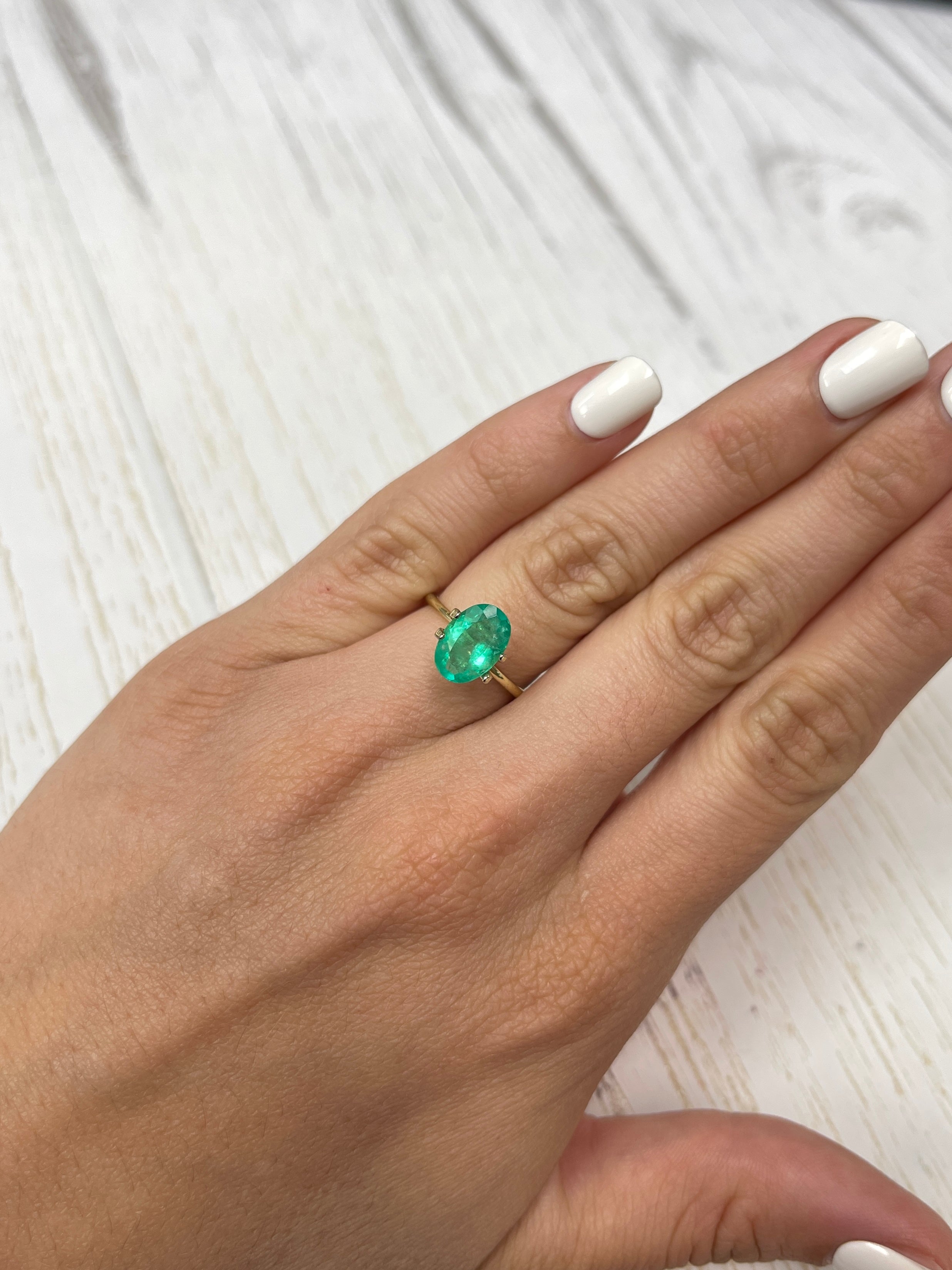 Elongated 11x8 mm Colombian emerald loose gemstone, 1.96 carats, vibrant apple green color, oval cut by JR Colombian Emeralds.