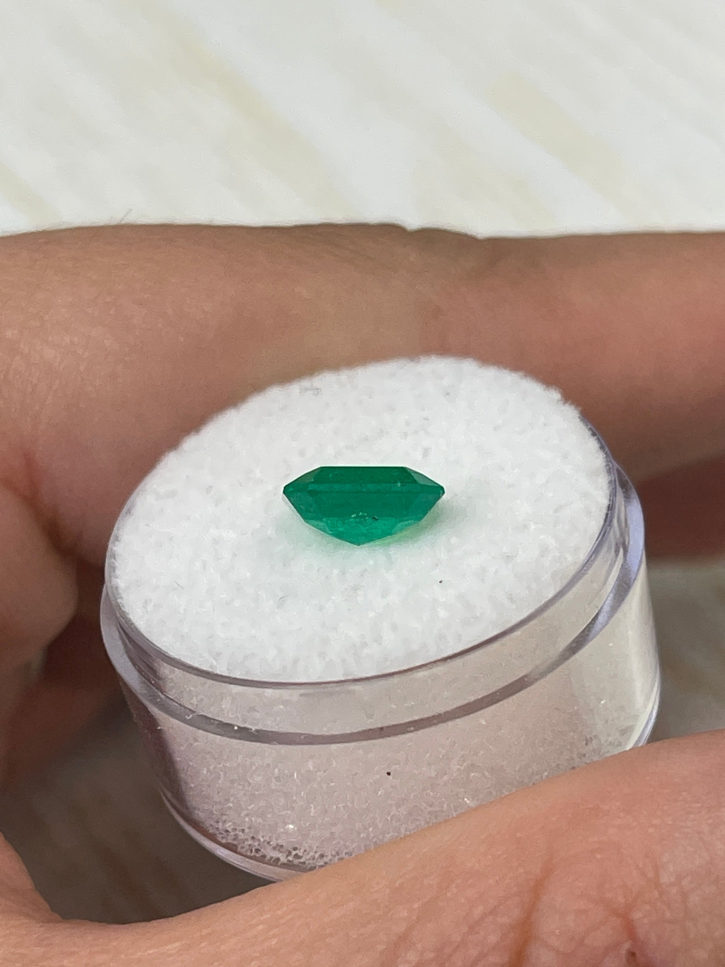 1.97 Carat spready Muzo green Colombian emerald loose Asscher cut gemstone from JR Colombian Emeralds on a white background.