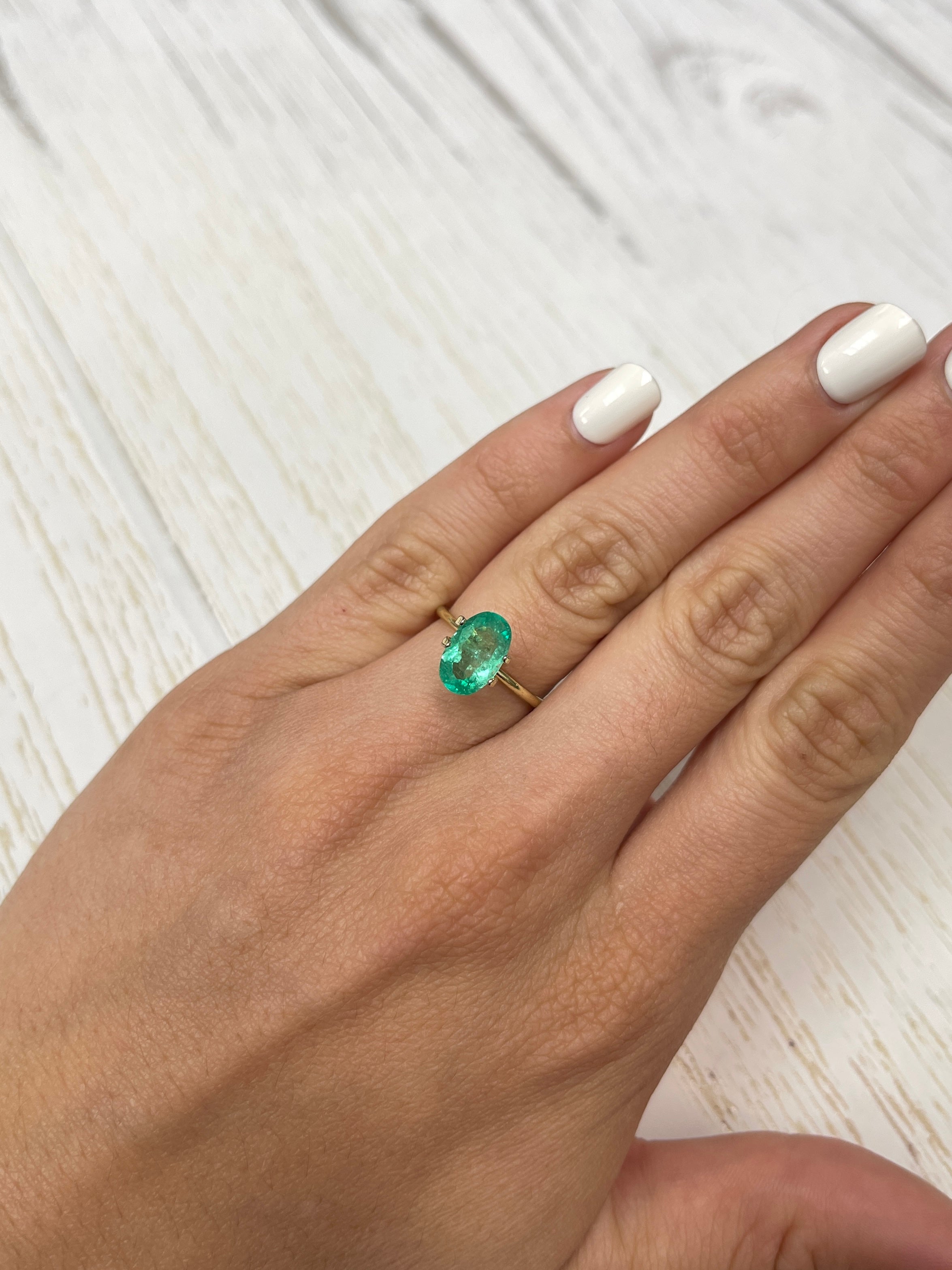 1.98 carat elongated oval green Colombian emerald loose gemstone from JR Colombian Emeralds, natural and vibrant in appearance.