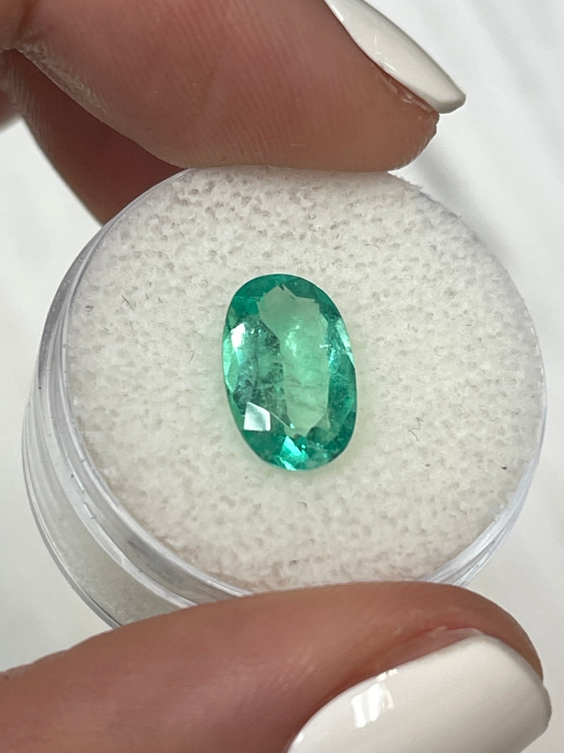 Elongated 2.31 carat natural Colombian emerald loose gemstone with oval cut, vibrant green color, from JR Colombian Emeralds.