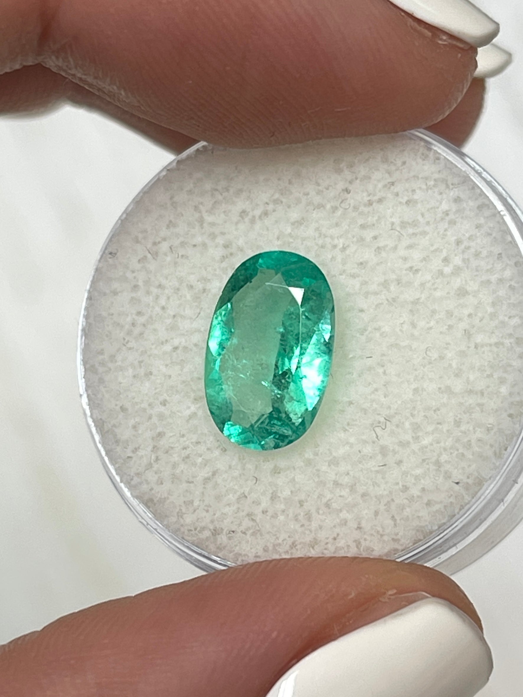 Elongated 2.31 carat natural Colombian emerald loose gemstone with oval cut, vibrant green color, from JR Colombian Emeralds.