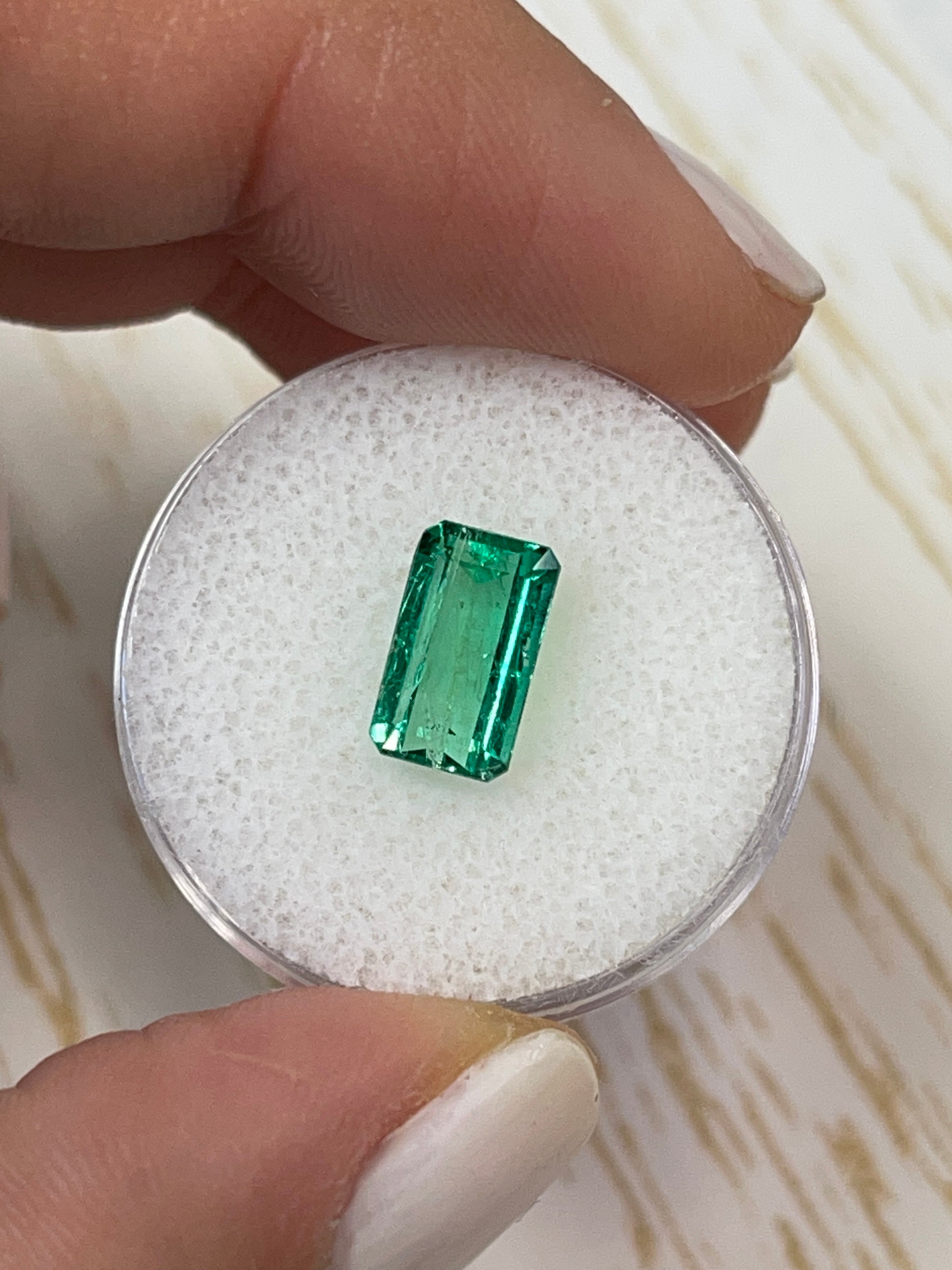 Loose 2.38 carat Muzo green Colombian emerald in an emerald cut, featuring a slender 10x6 mm shape, from JR Colombian Emeralds.