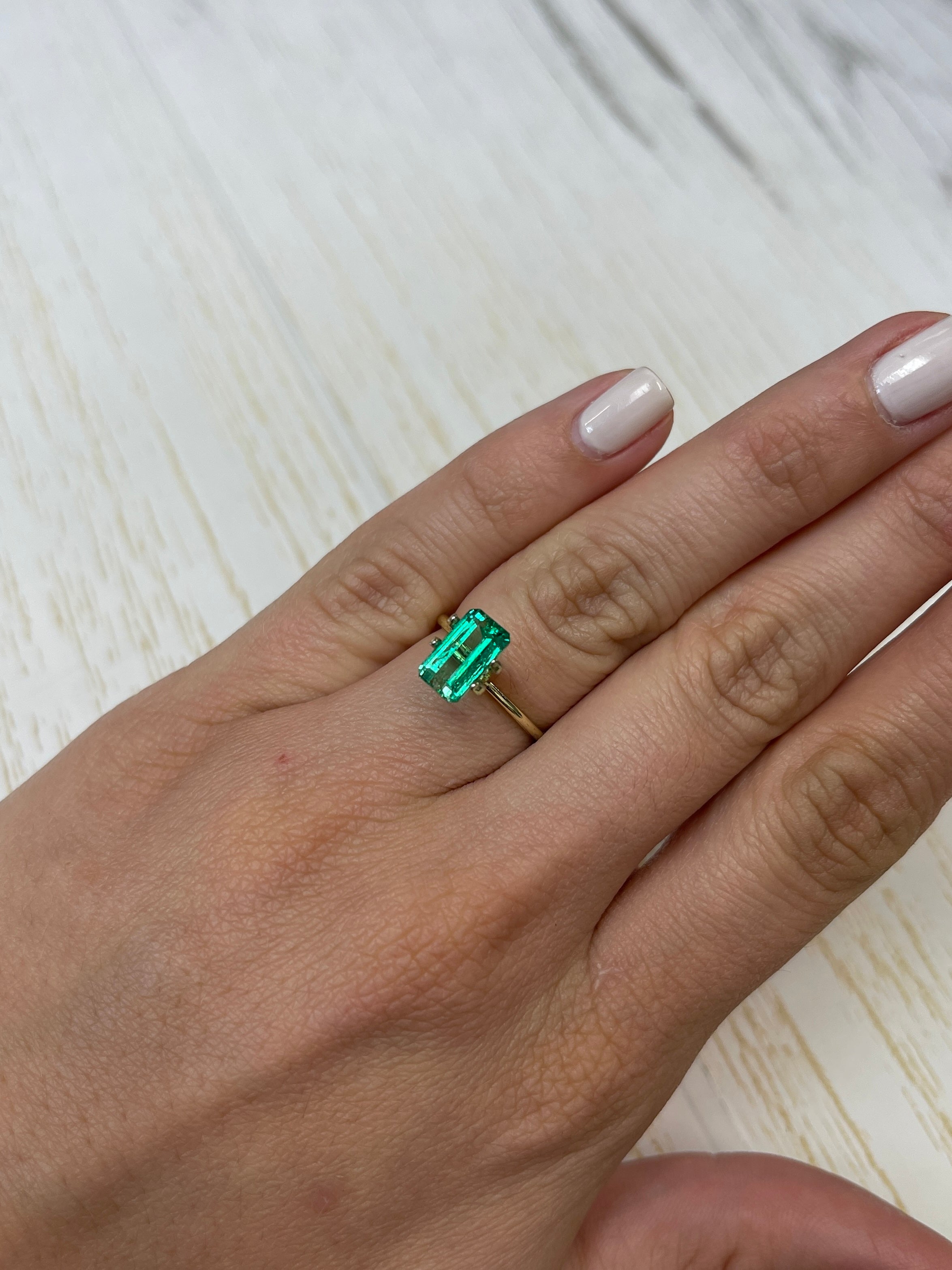 2.38 carat slender Muzo green Colombian emerald loose gemstone in an emerald cut, showcasing vibrant green color and clarity.