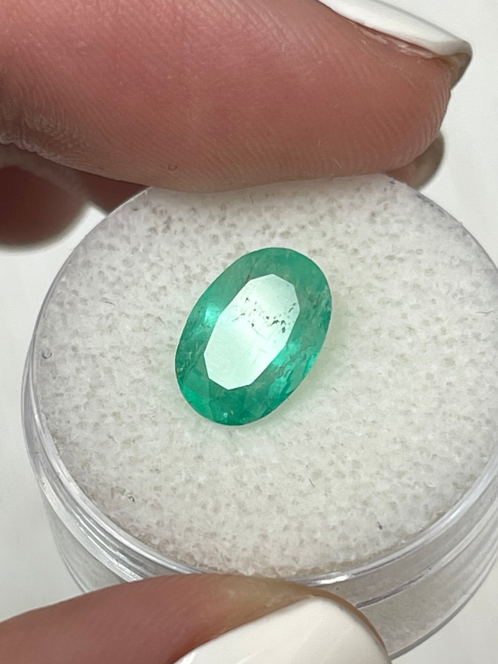Loose 2.40 carat medium light green Colombian emerald in oval cut, showcased by JR Colombian Emeralds.