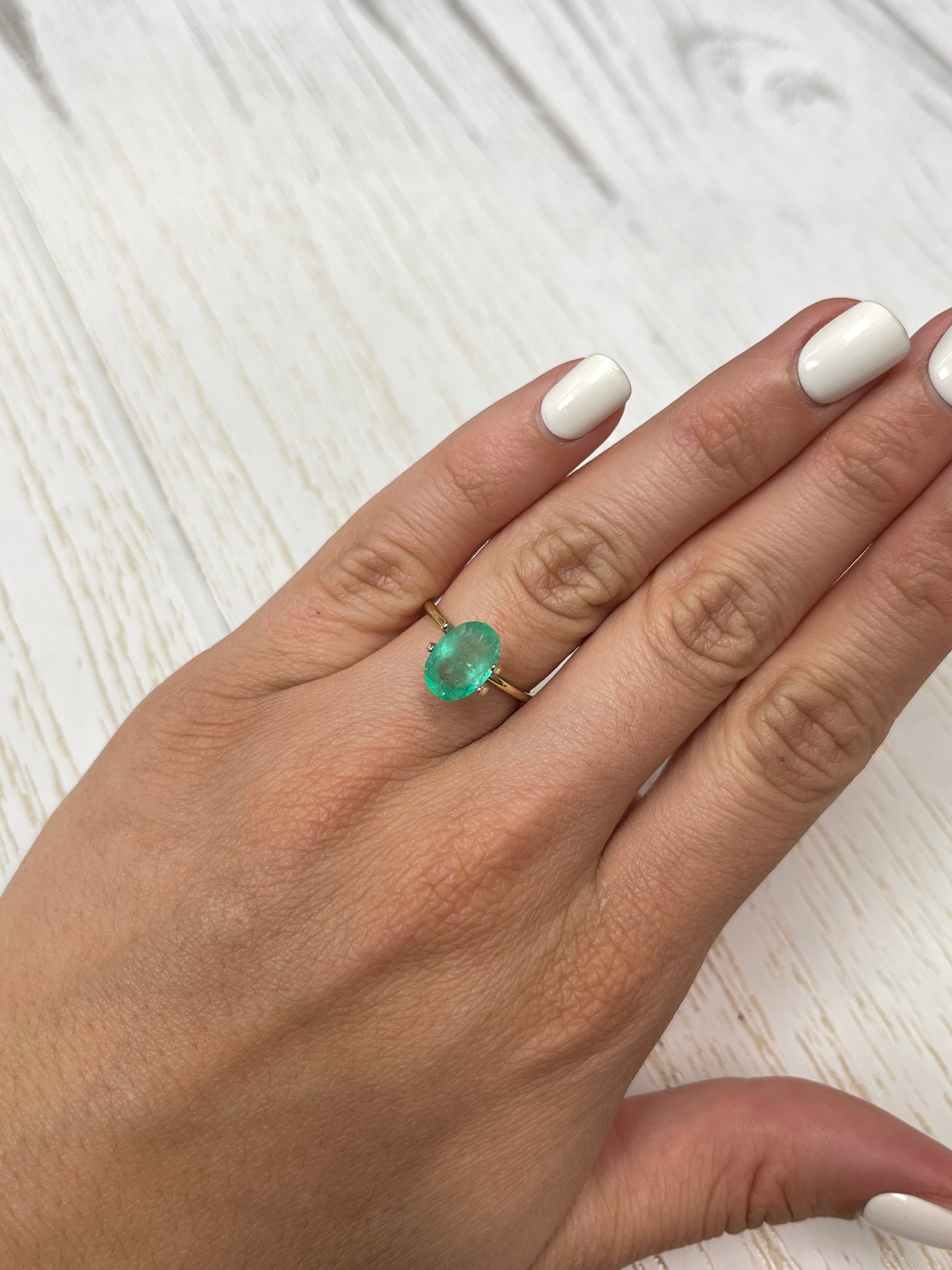 Oval cut 2.40 carat medium light green Colombian emerald from JR Colombian Emeralds, showcasing its vibrant, slender loose gemstone.
