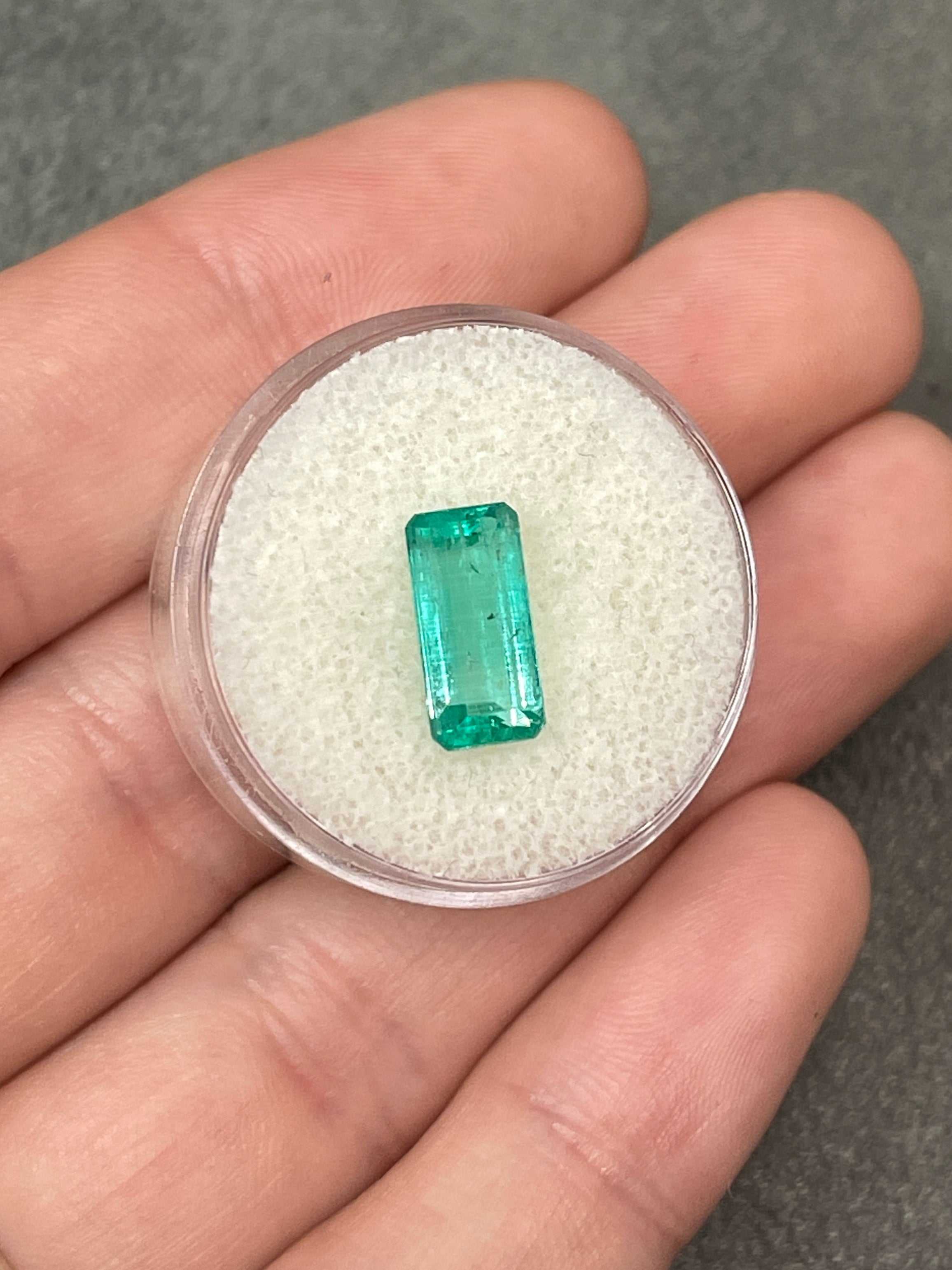 Light bluish green 2.57 carat natural Colombian emerald loose gemstone with an elongated emerald cut, showcased by JR Colombian Emeralds.