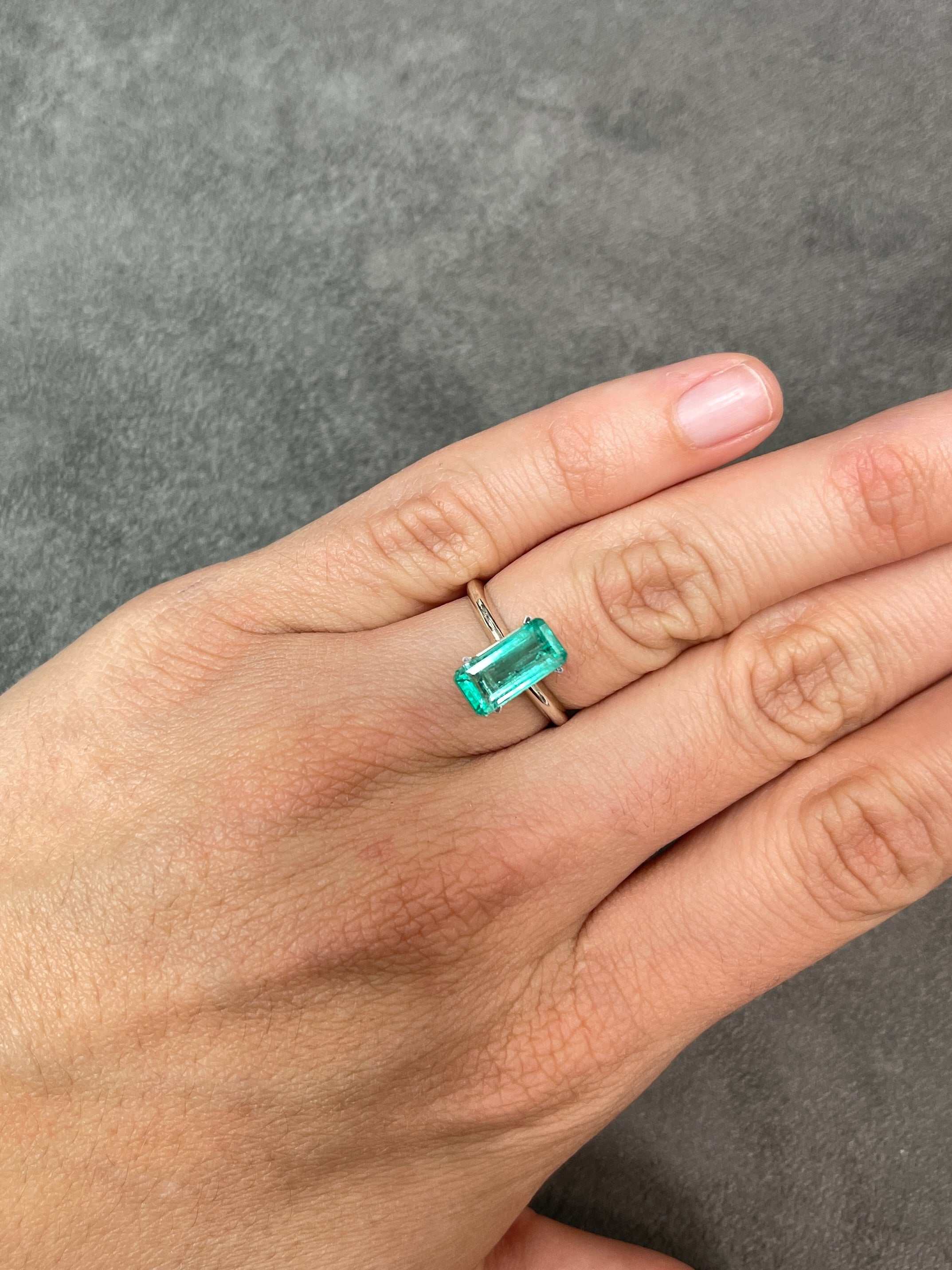 2.57 Carat light bluish green natural Colombian emerald loose gemstone in an elongated emerald cut, displayed by JR Colombian Emeralds.