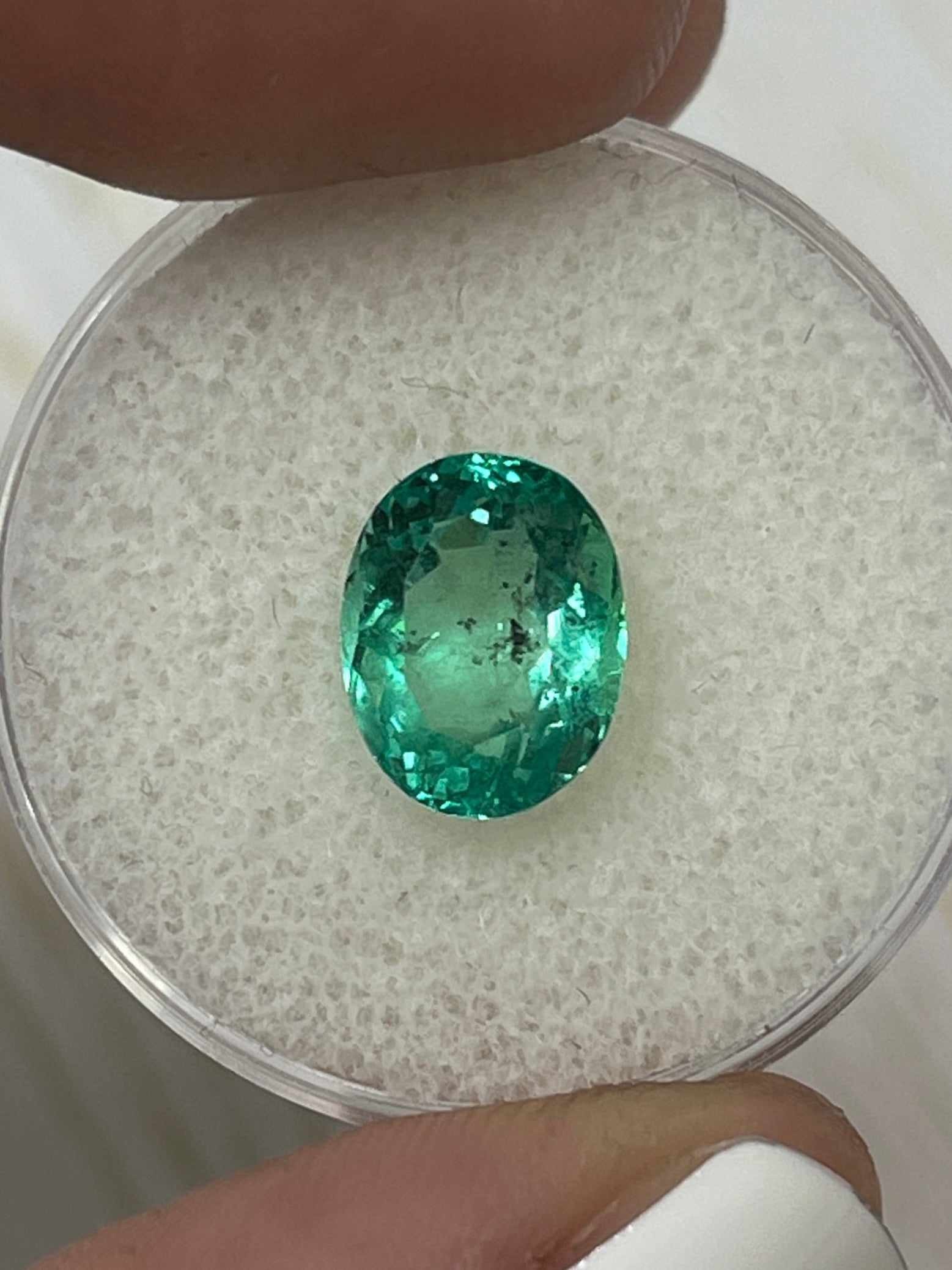 Vibrant 2.83 carat green Colombian emerald loose oval cut gemstone with natural freckled appearance, from JR Colombian Emeralds.