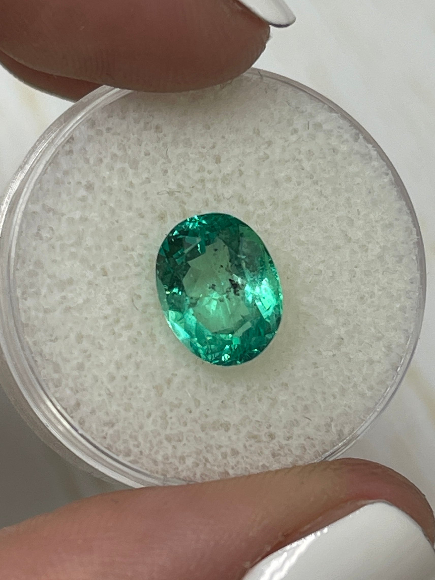 Vibrant 2.83 Carat oval cut Colombian emerald with natural freckles, loose gemstone from JR Colombian Emeralds.