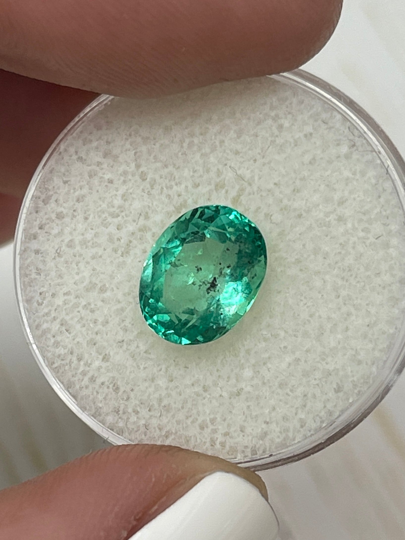 Vibrant 2.83 carat oval cut Colombian emerald loose gemstone with natural green color and distinctive freckles, by JR Colombian Emeralds.