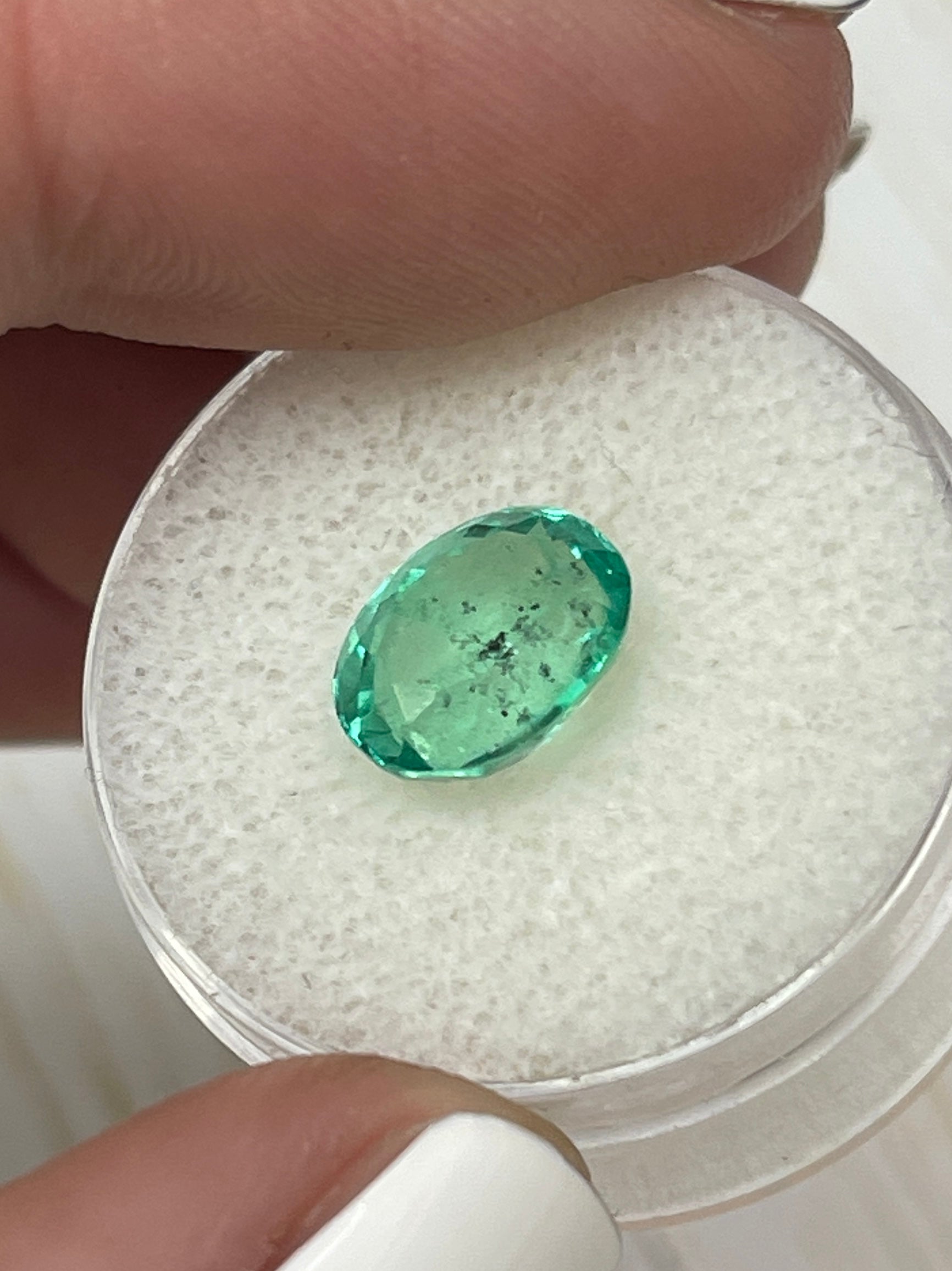 Vibrant 2.83 carat oval-cut Colombian emerald with natural freckles, loose gemstone from JR Colombian Emeralds.