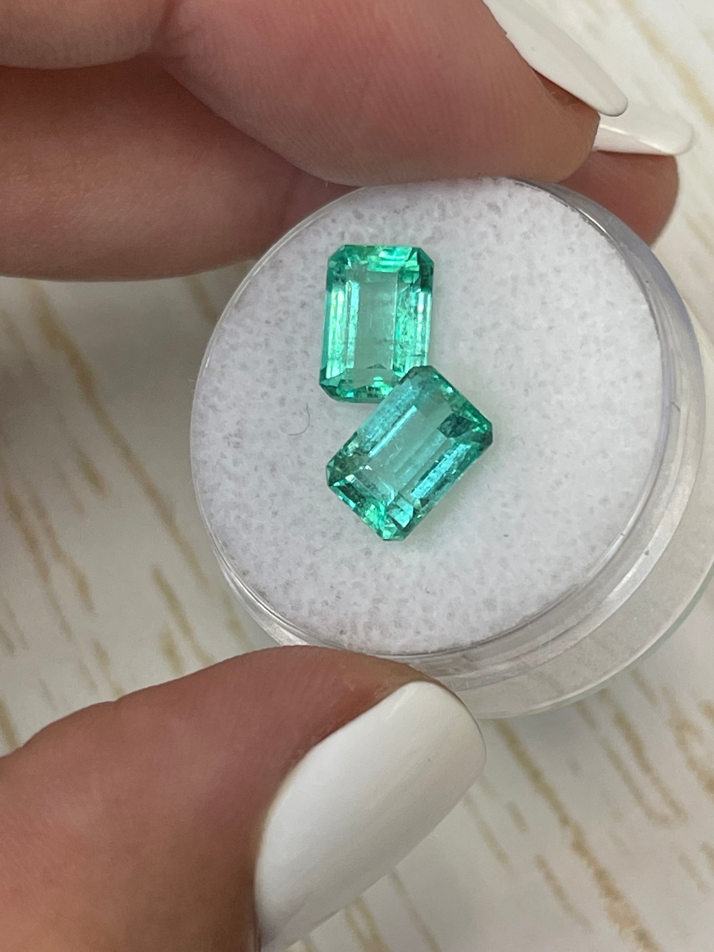 3.93tcw 9x6 matching loose Colombian emeralds emerald cut medium light green stones in round container