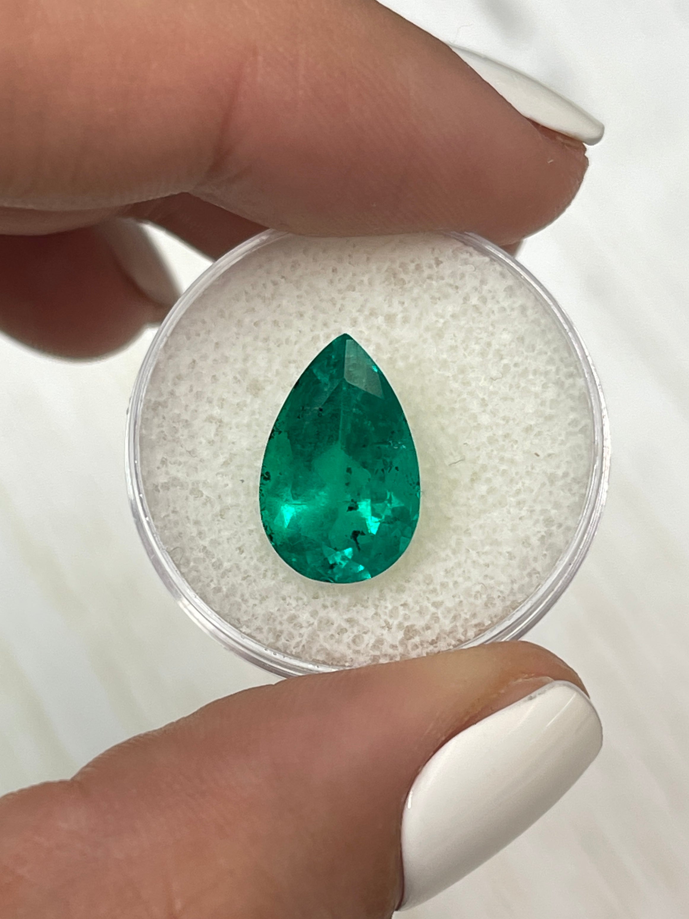 Natural 5.18 carat Colombian emerald in pear cut with freckles, 14.5x9mm, showcasing vibrant green color and unique inclusions.