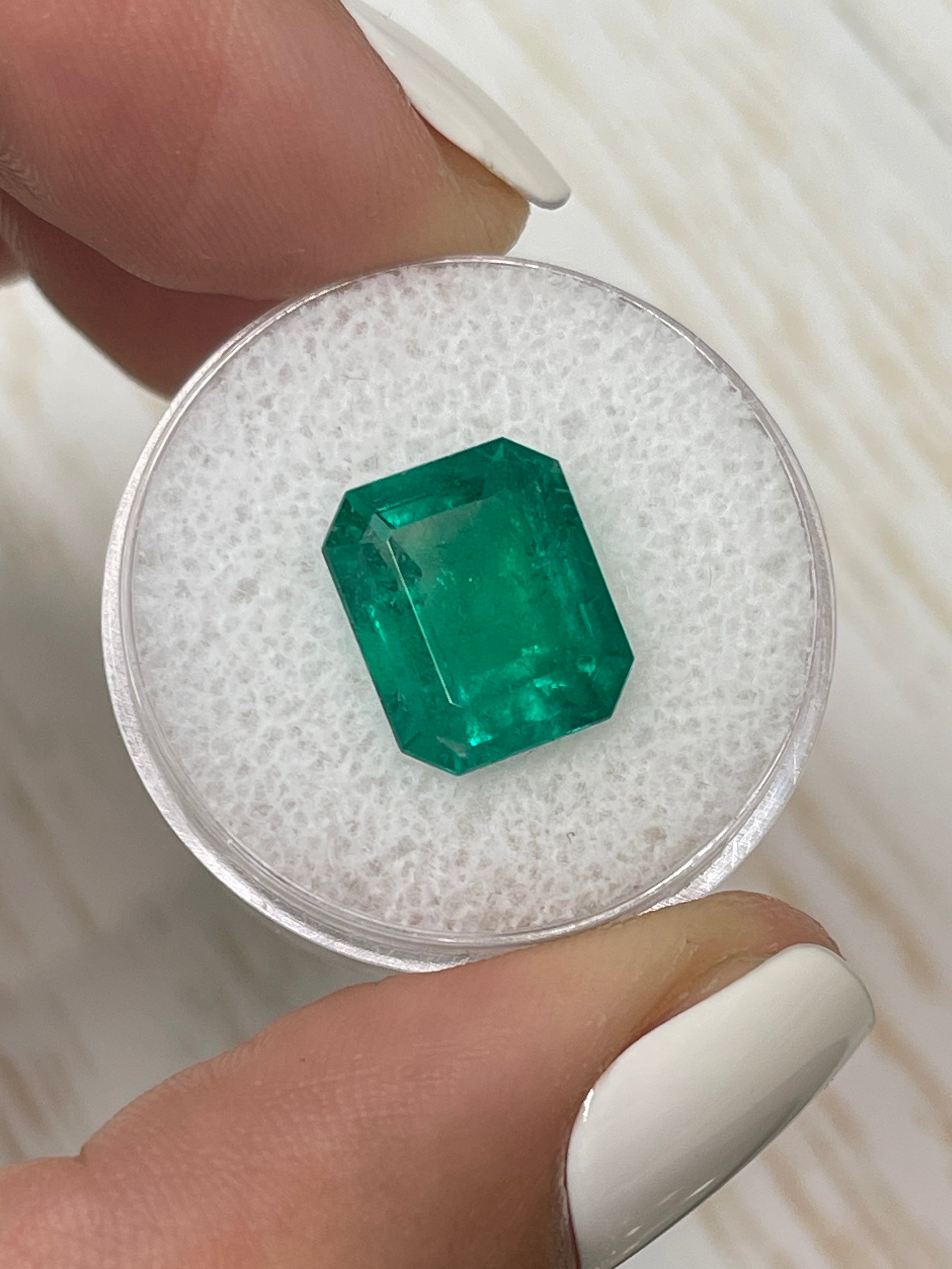 Fine 5.20 carat natural Colombian emerald in 12x10 emerald cut, showcasing vibrant green color and clarity, from JR Colombian Emeralds.