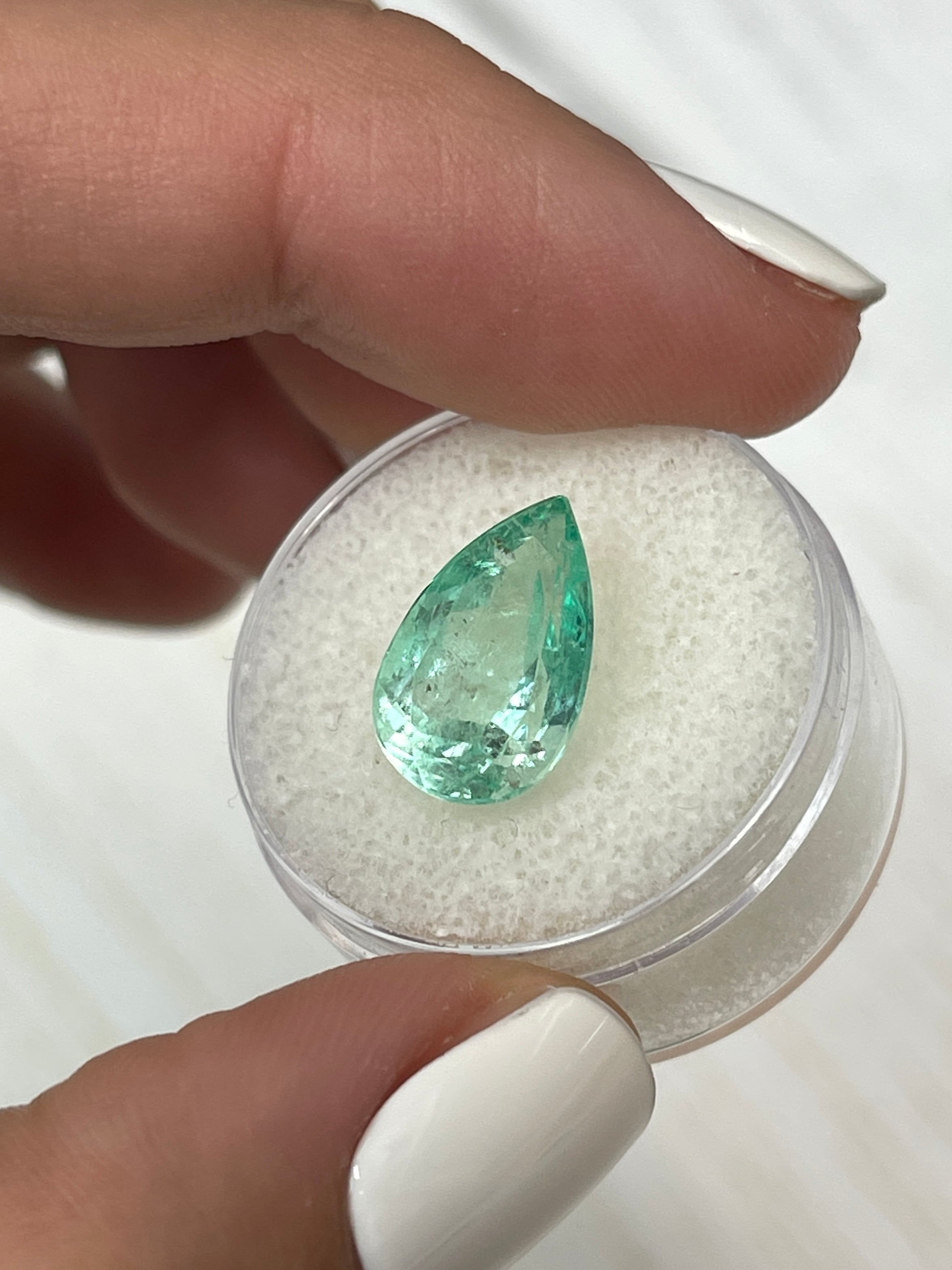 Light green 5.57 carat natural Colombian emerald in pear cut, showcasing its luminous glow and vibrant color.