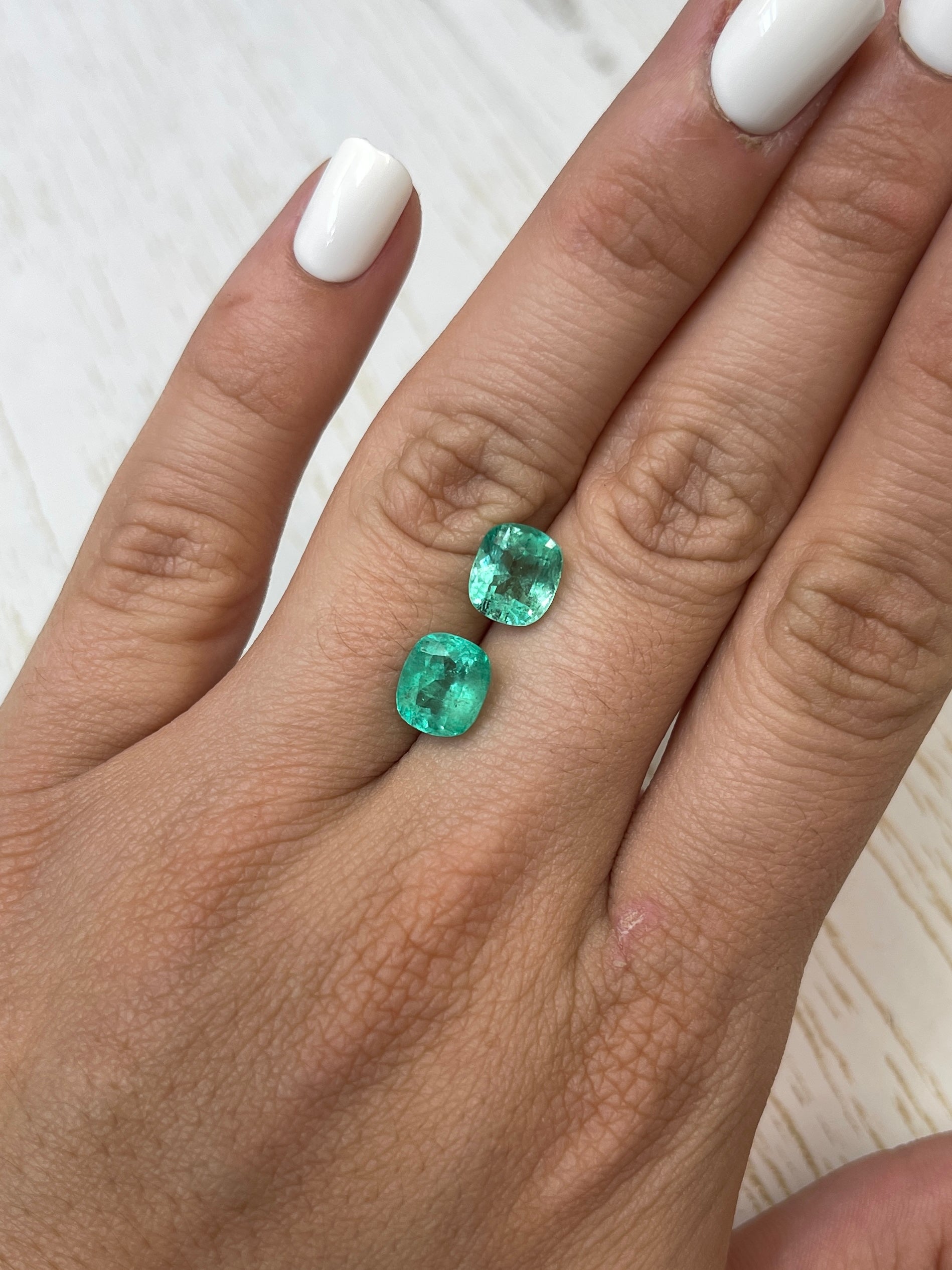 Nine 9x8mm light bluish green Colombian emeralds, cushion cut, natural loose gemstones, from JR Colombian Emeralds.
