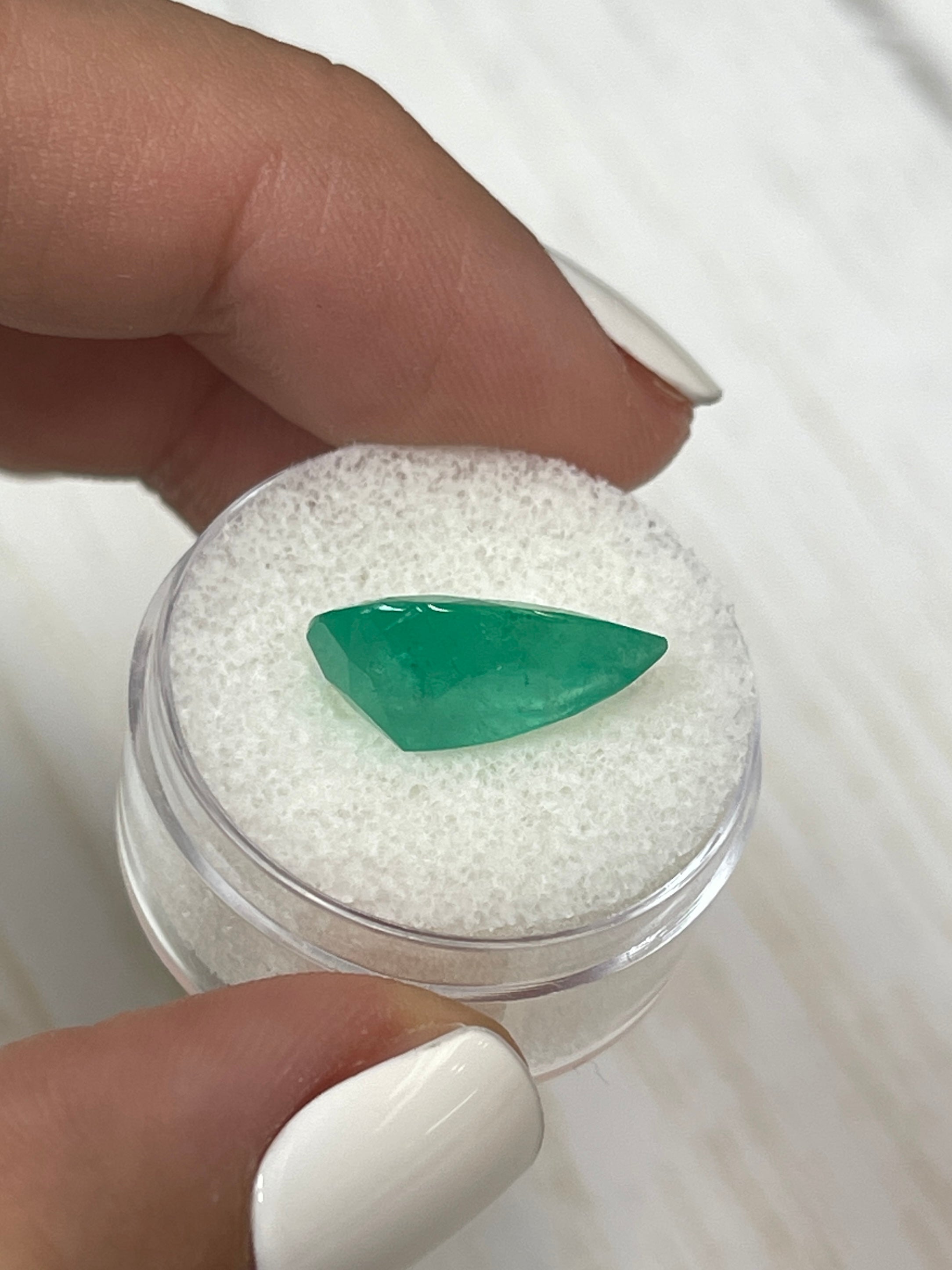 Natural 5.63 Carat Apple Green Colombian Emerald loose gemstone in pear cut, showcasing vibrant color and clarity.