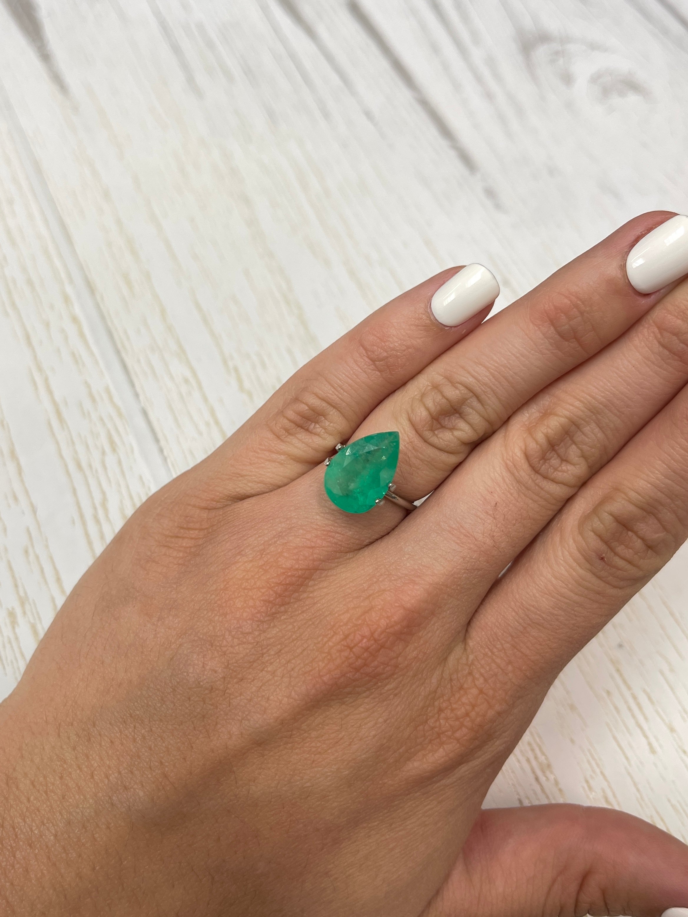 5.63 carat apple green natural Colombian emerald loose gemstone with pear cut, showcased by JR Colombian Emeralds.