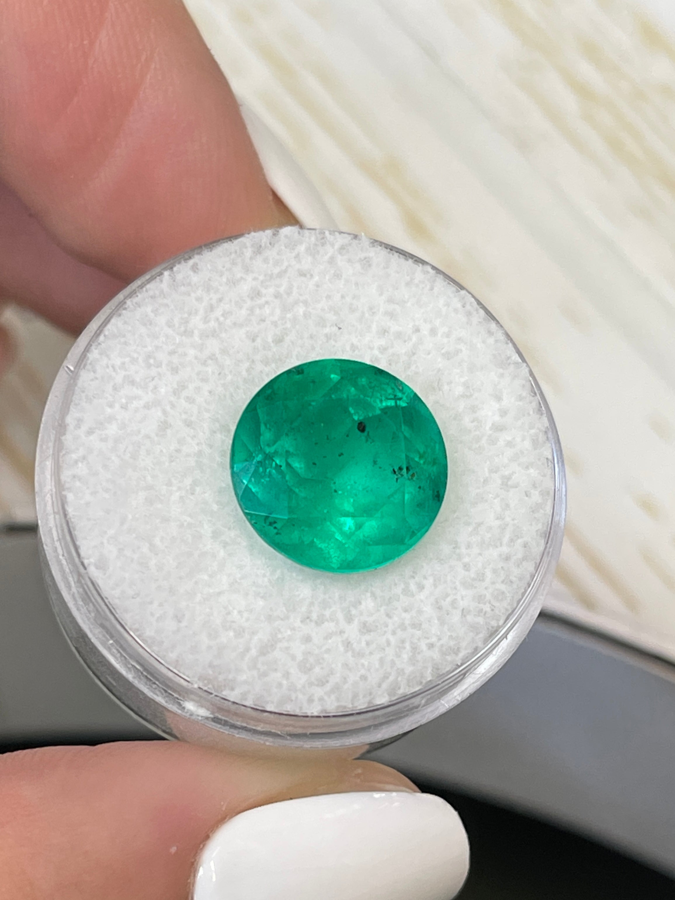 6.16 carat natural round Colombian emerald with freckled green color, loose gemstone from JR Colombian Emeralds.