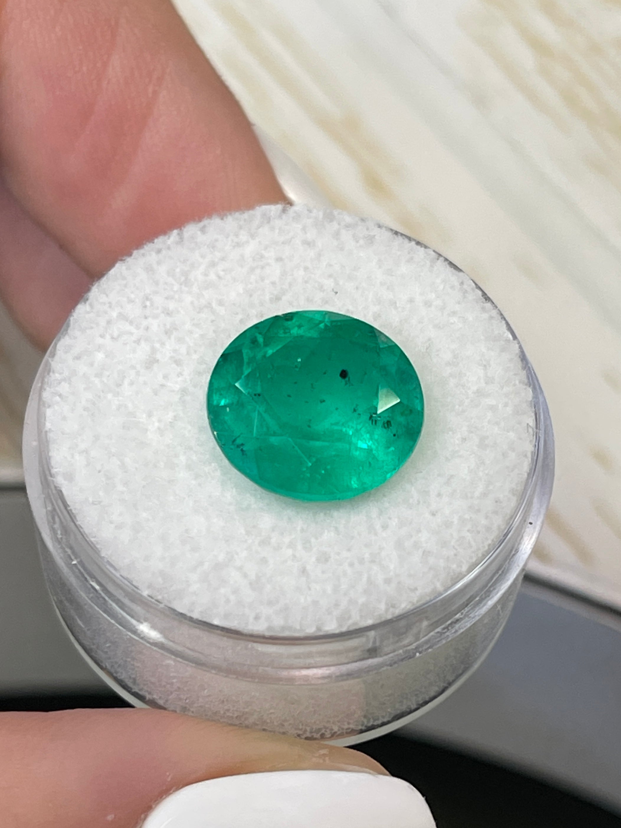 6.16 carat natural round Colombian emerald with freckled green color, loose gemstone from JR Colombian Emeralds.
