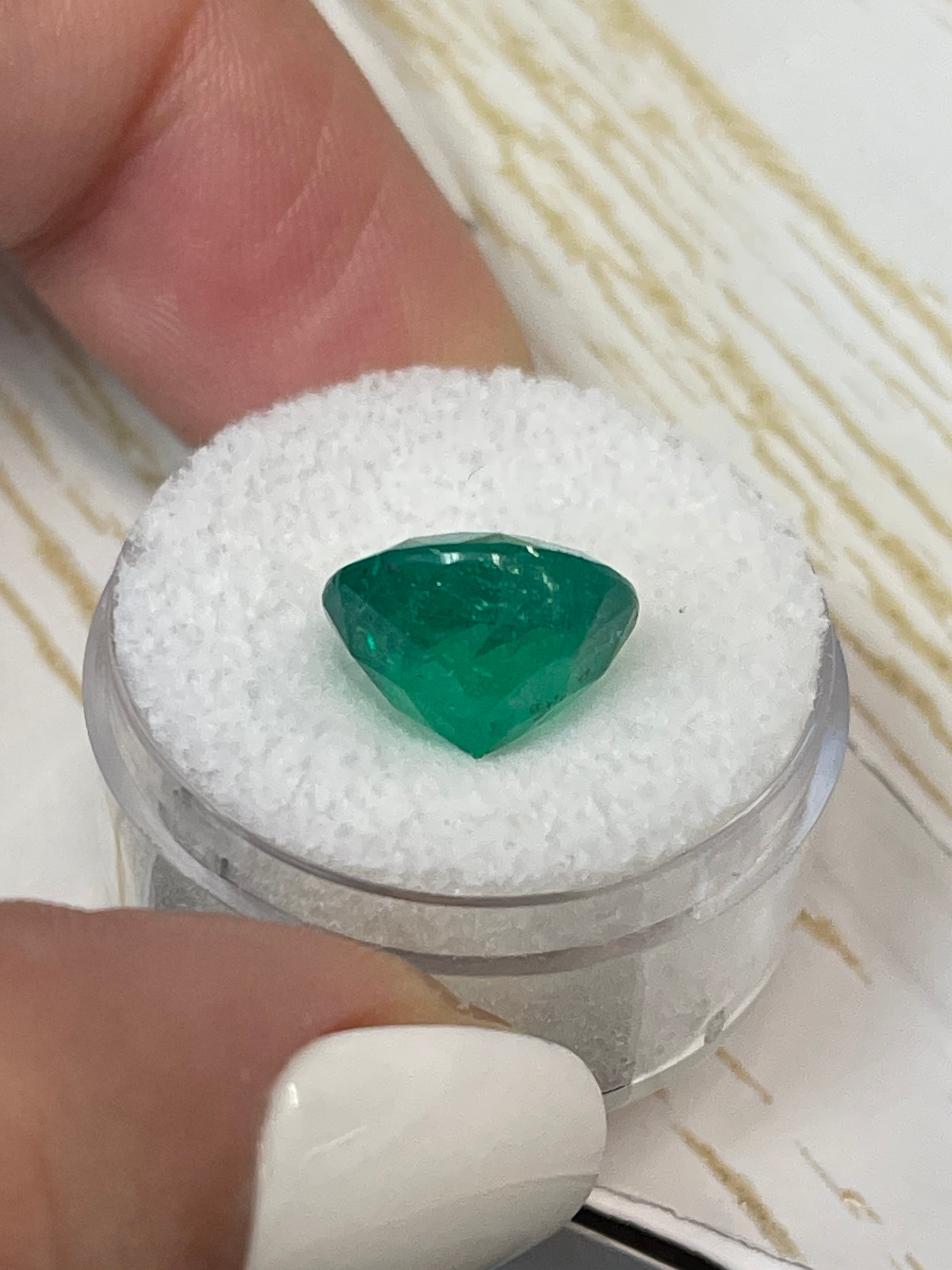 6.16-carat natural round Colombian emerald with green color and freckles, loose gemstone from JR Colombian Emeralds.