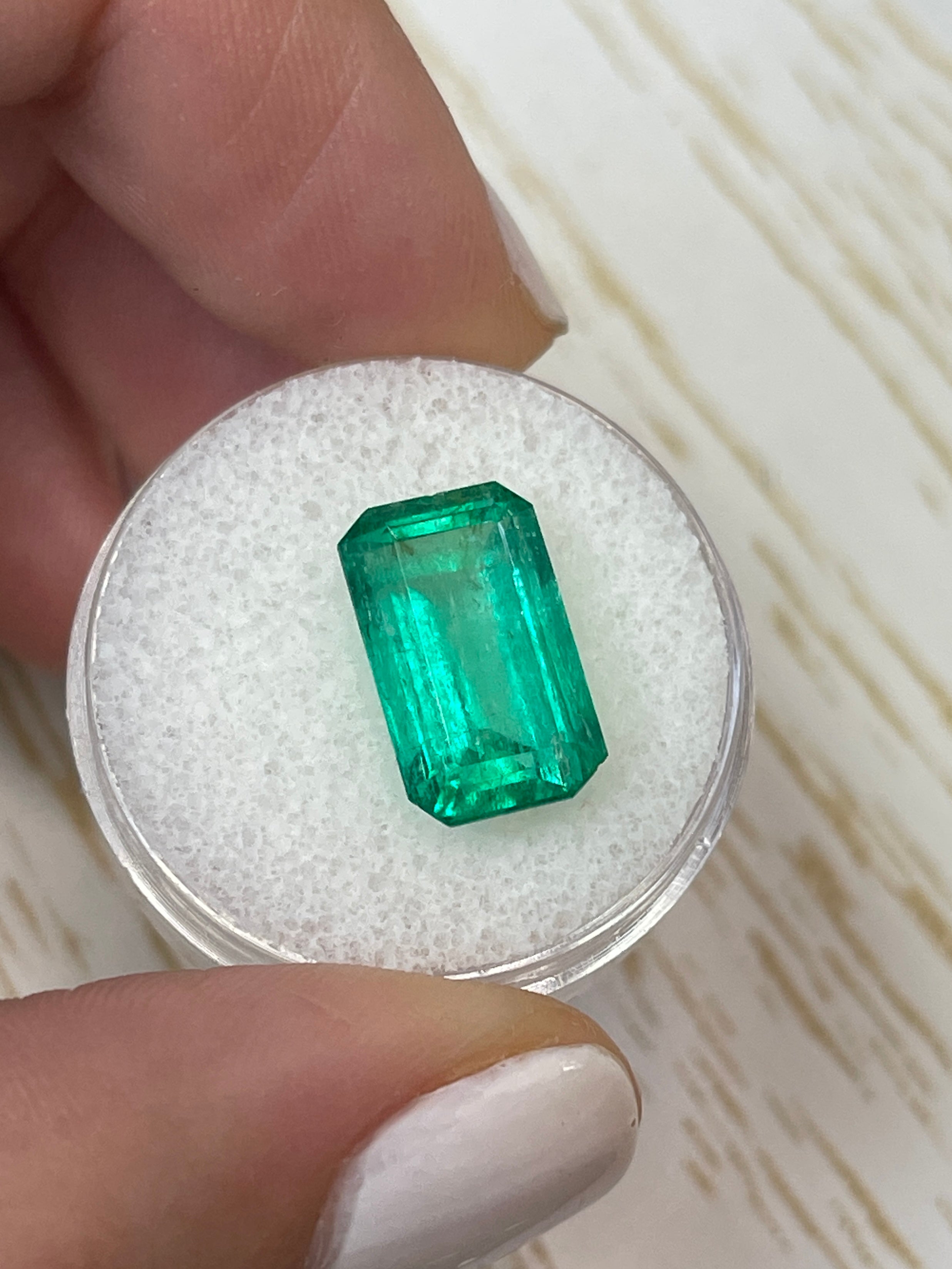 6.22 carat bluish-green Colombian emerald cut loose gemstone showcasing vibrant color and clarity.