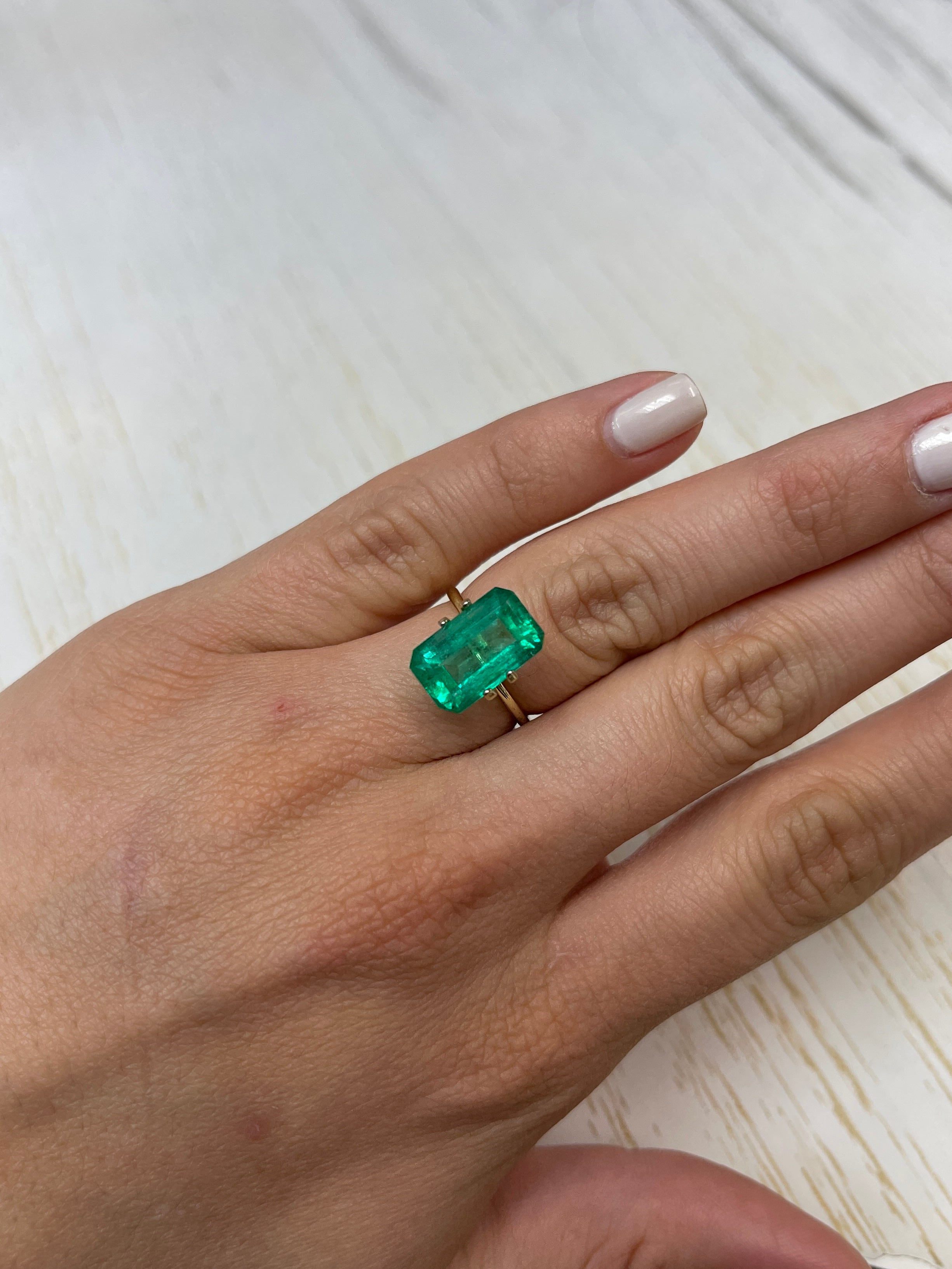Bluish green 6.22 carat Colombian emerald cut loose gemstone with a rectangular shape and vibrant color.