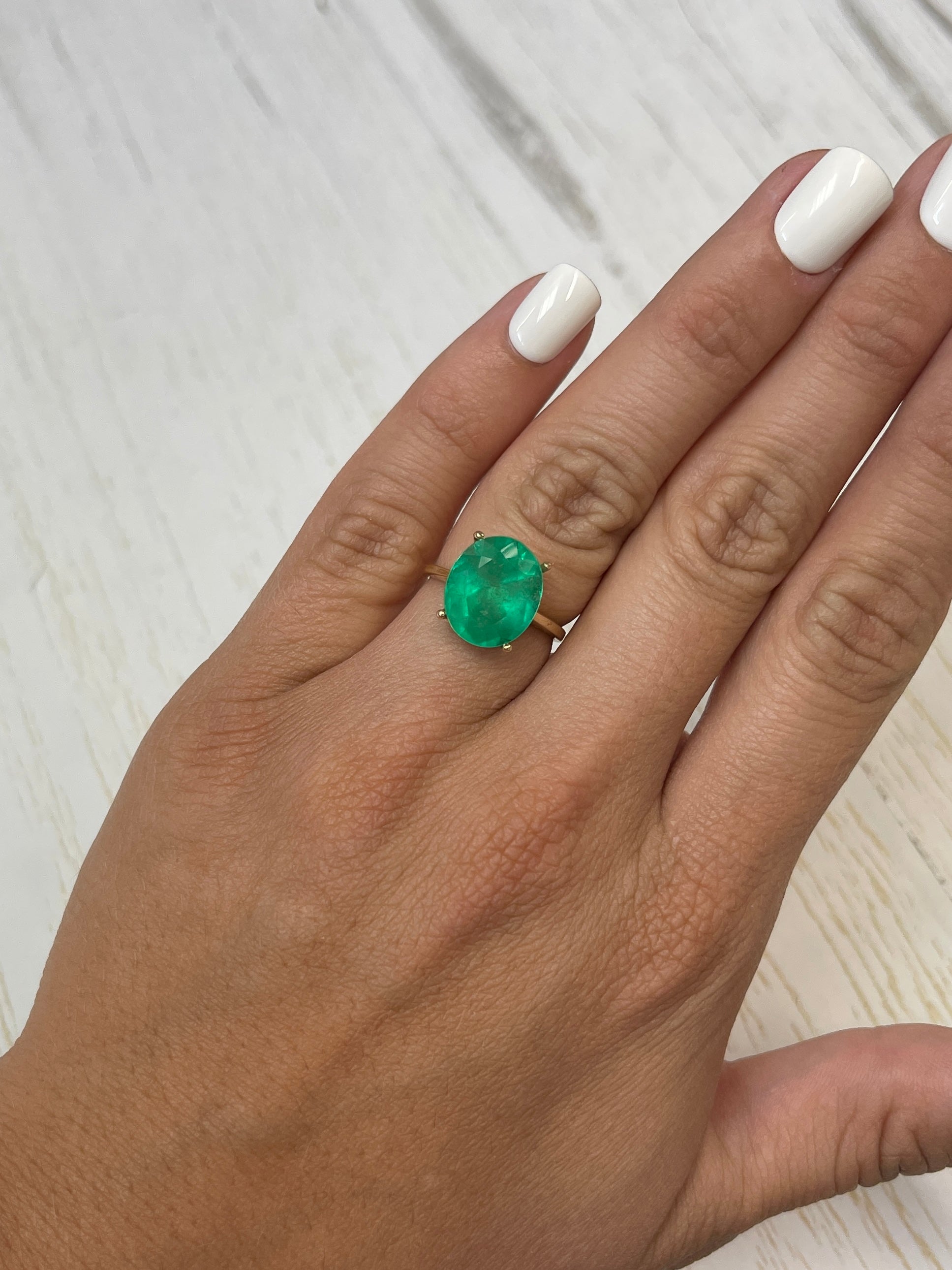 Neon green 6.35 carat oval cut Colombian emerald loose gemstone from JR Colombian Emeralds, natural and vibrant in appearance.