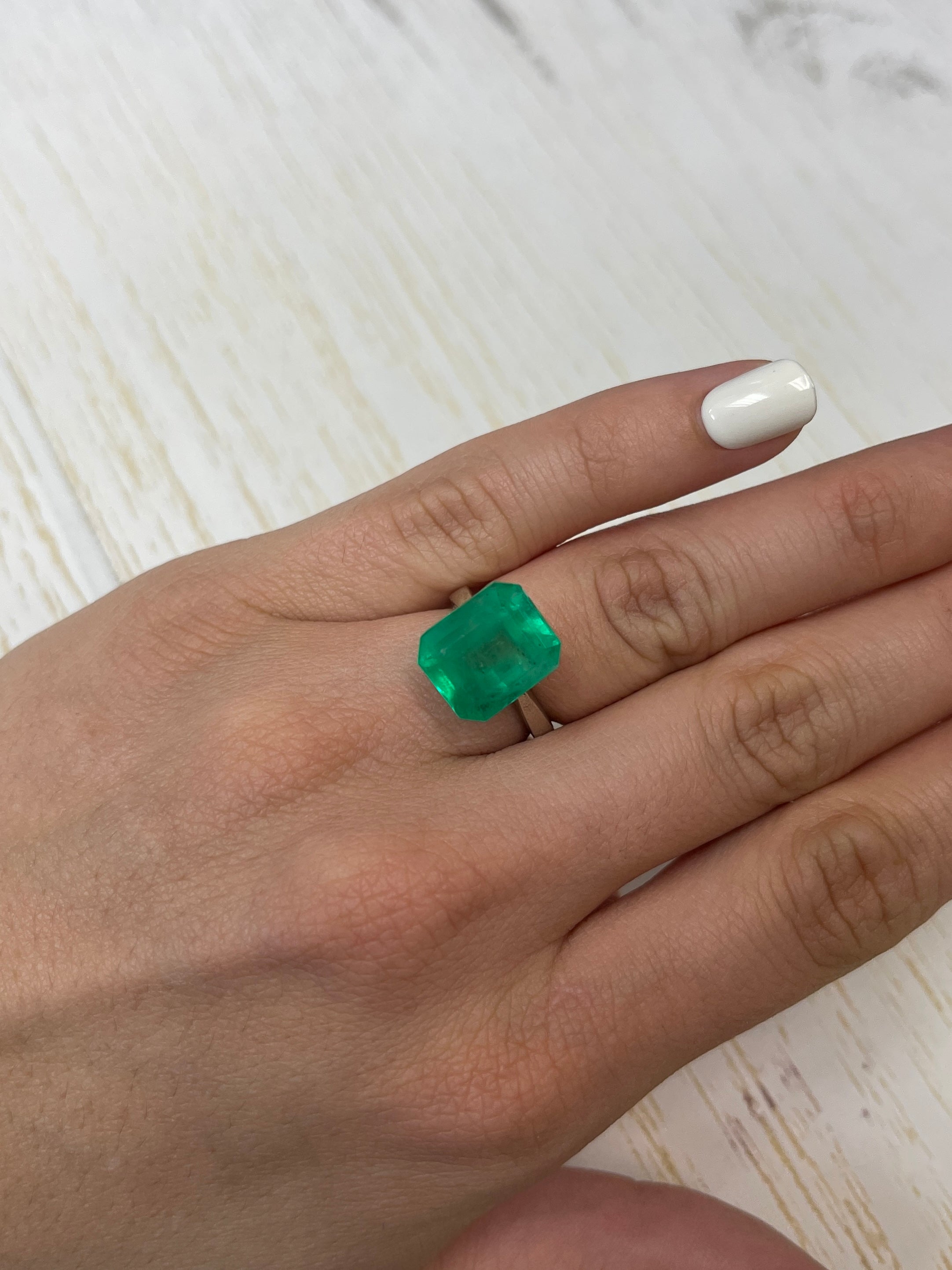 Yellowish green 9.28 carat Colombian emerald cut loose gemstone from JR Colombian Emeralds, showcasing its vibrant color and clarity.