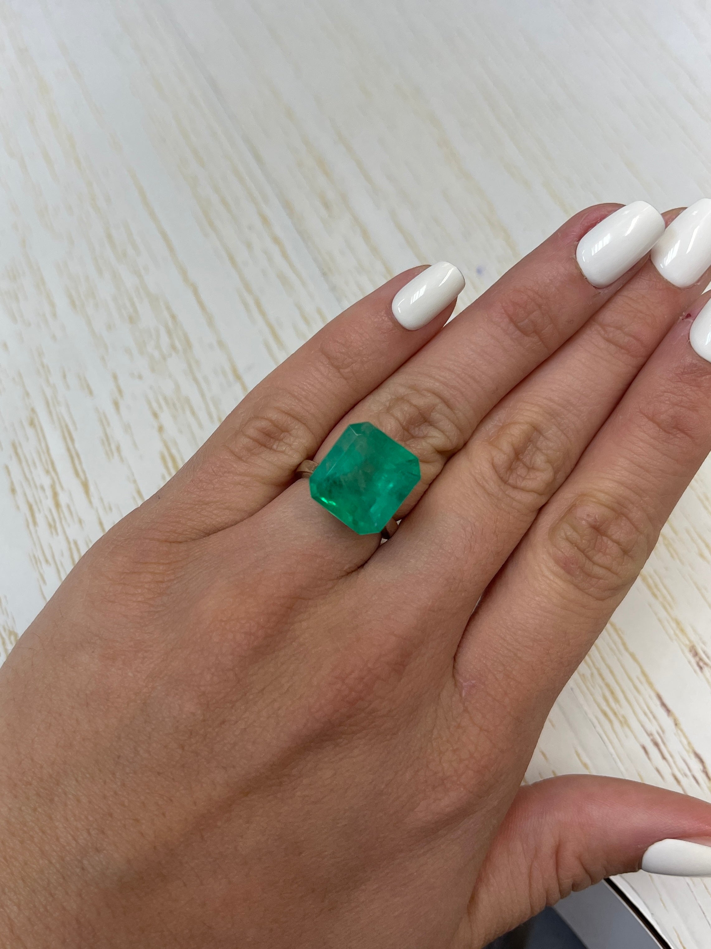 Large 12.09 carat Colombian emerald in an Asscher cut, showcasing vibrant green color and clarity, from JR Colombian Emeralds.