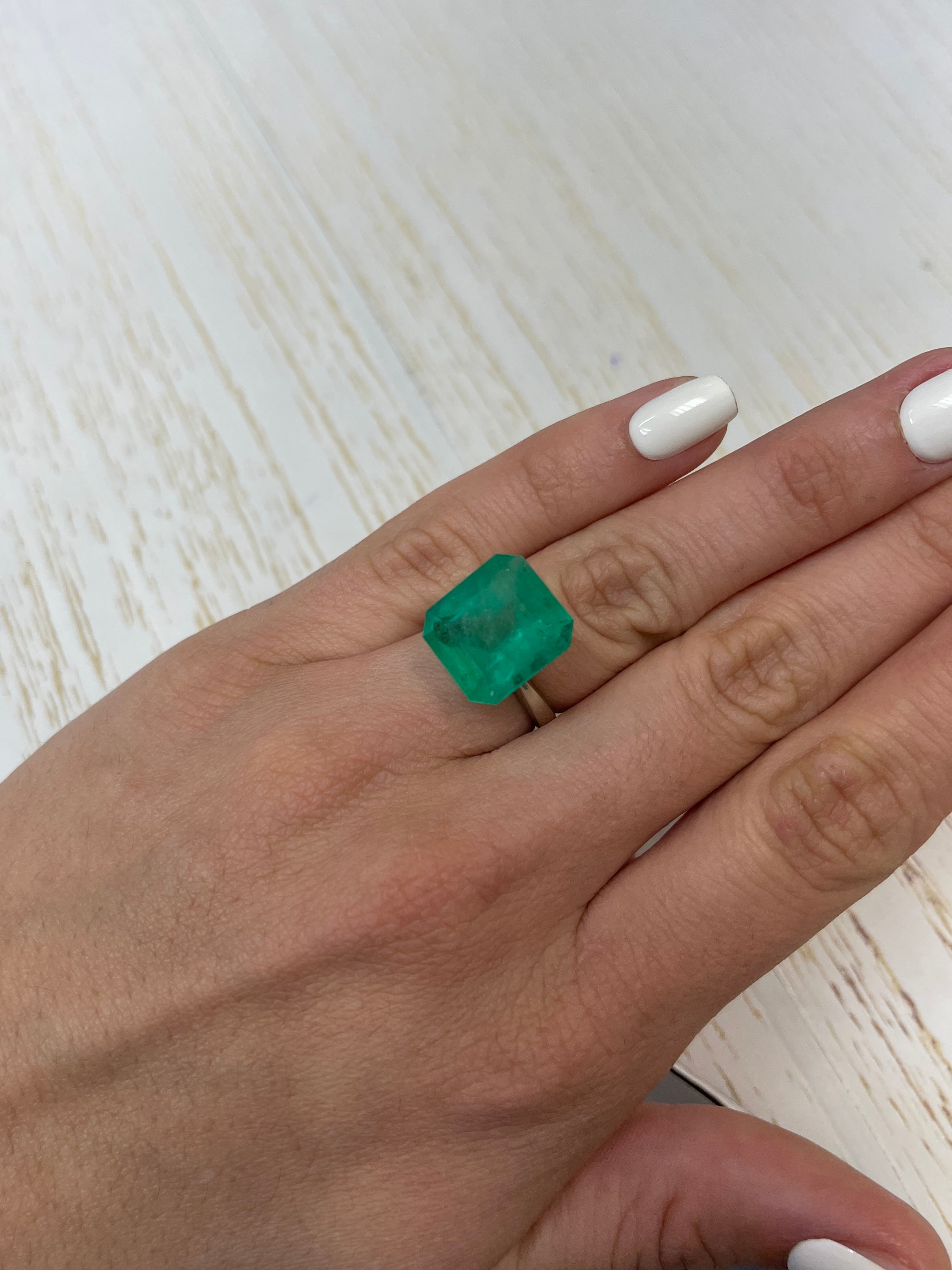 Large 12.09-carat Colombian emerald in an Asscher cut, showcasing vibrant green color and clarity, from JR Colombian Emeralds.