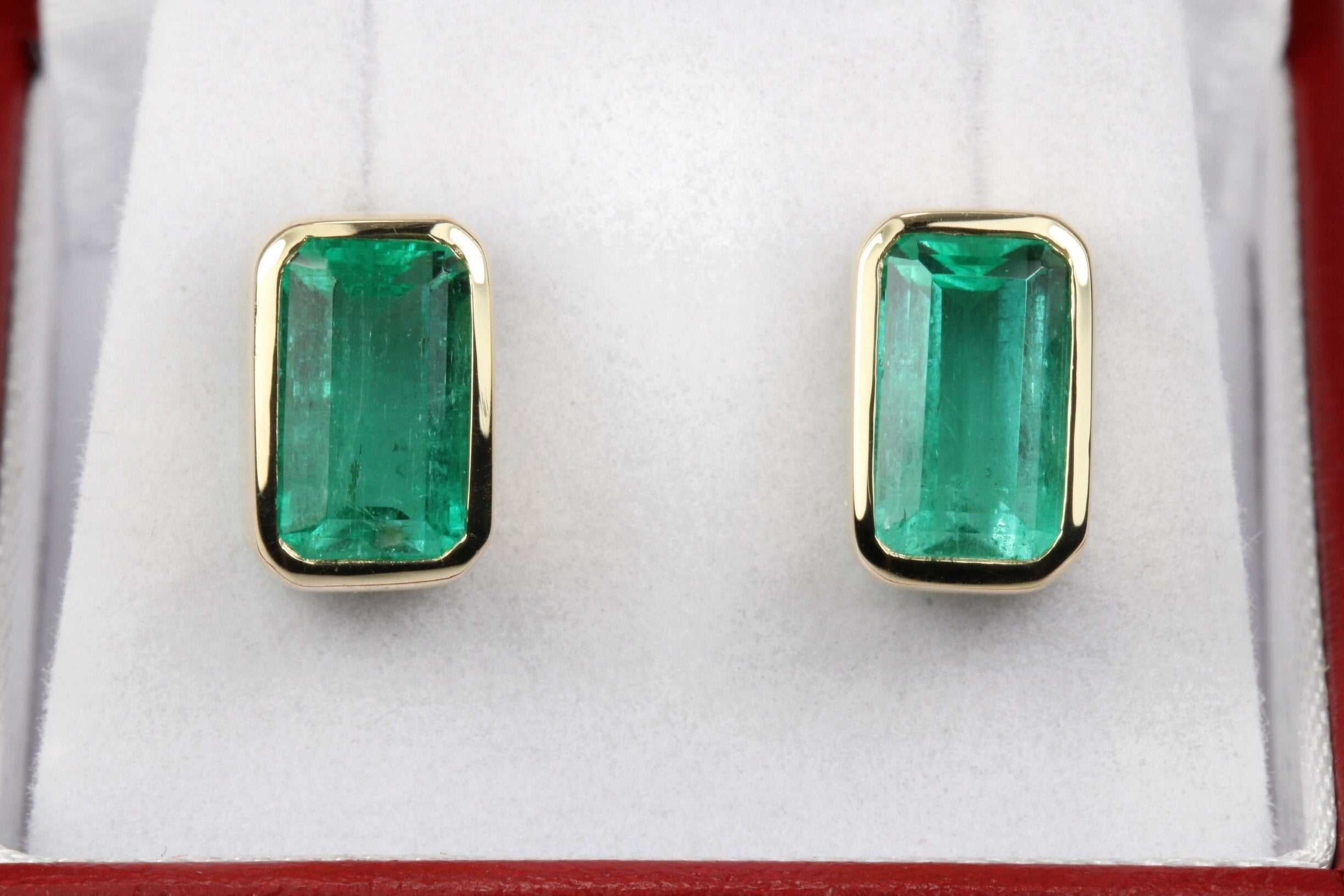 JR Colombian Emeralds 4.86tcw bezel set emerald cut Colombian emerald stud earrings in 14K gold, showcasing high-quality gemstones.