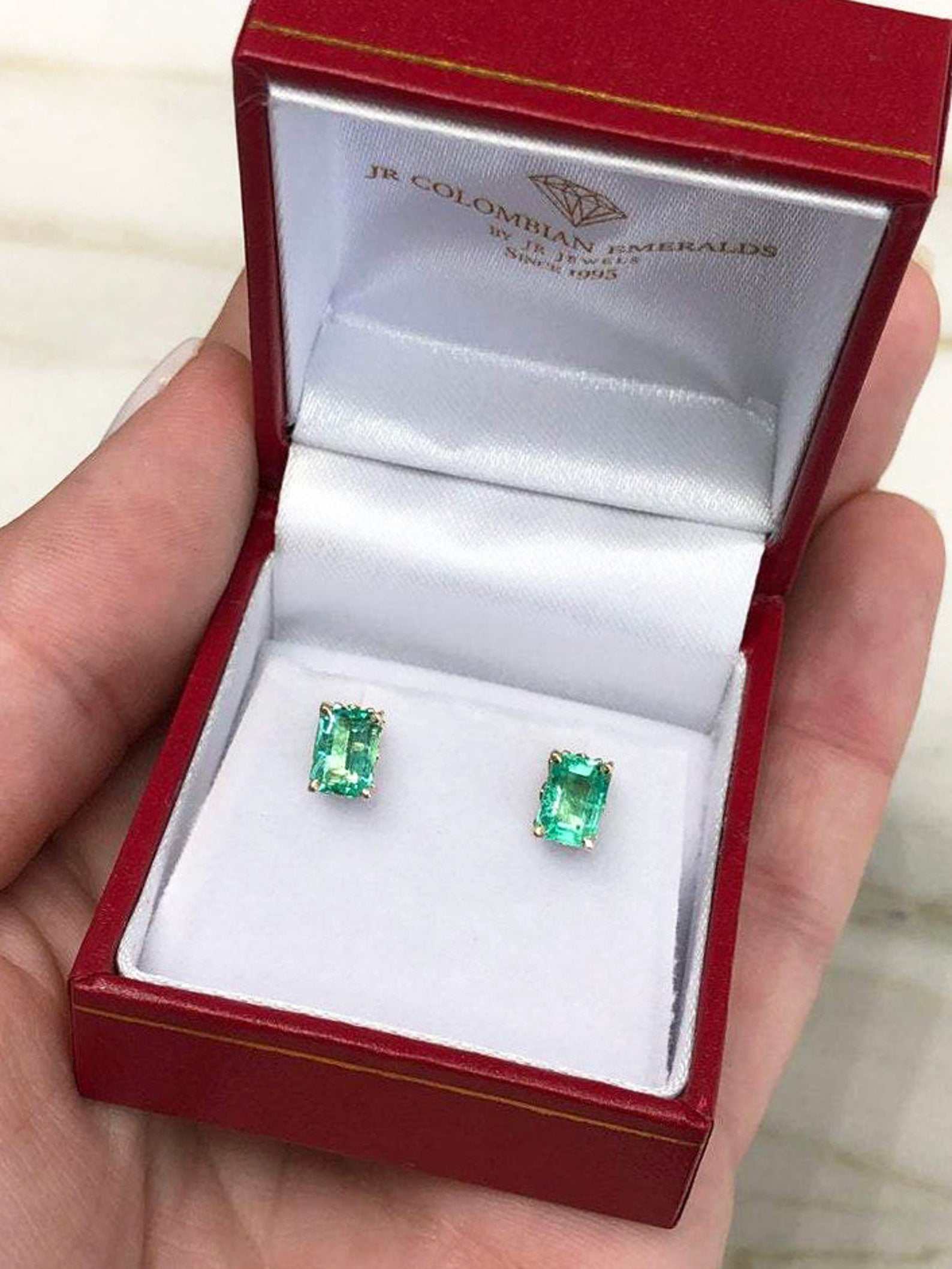 Trendy 1.50tcw emerald cut Colombian emerald stud earrings in 14K gold by JR Colombian Emeralds, showcasing elegant gemstone design.