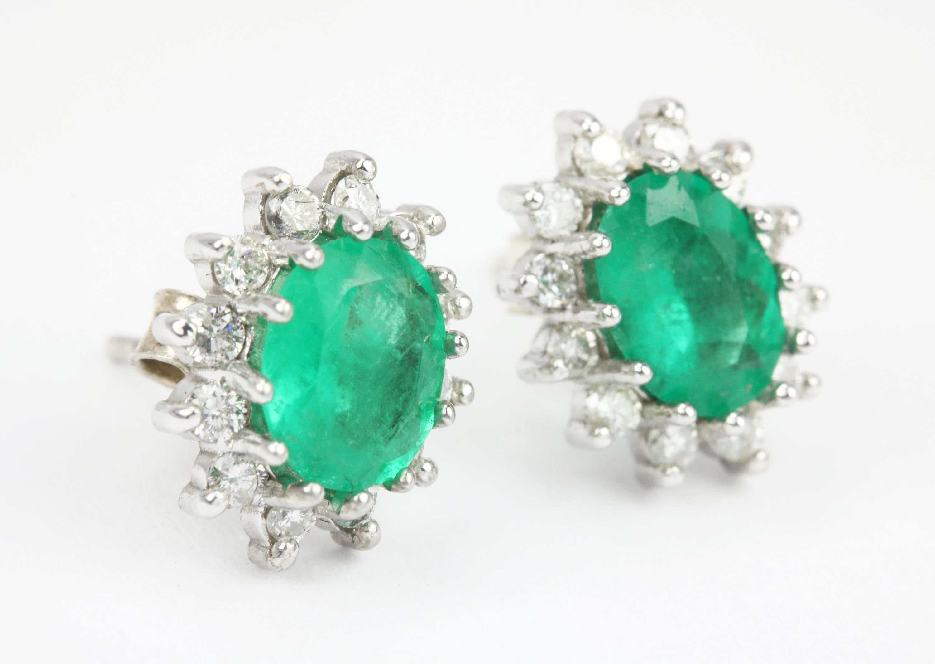 14K gold emerald and diamond cluster halo earrings with oval and round cuts, featuring 2.55 carats total weight.