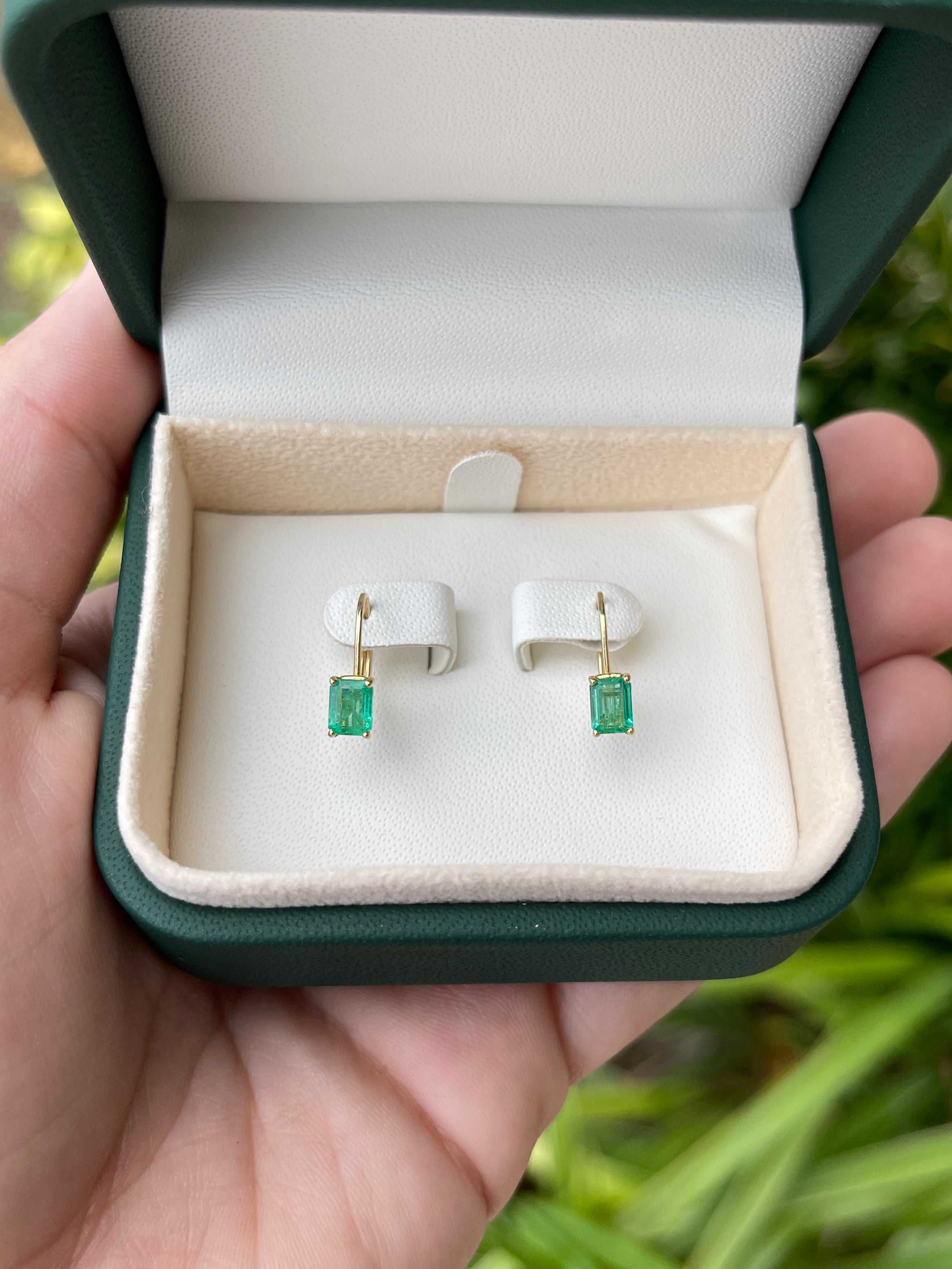 JR Colombian Emeralds 14K gold earrings with 1.50tcw natural emerald-cut emeralds, prong set with lever back closure.