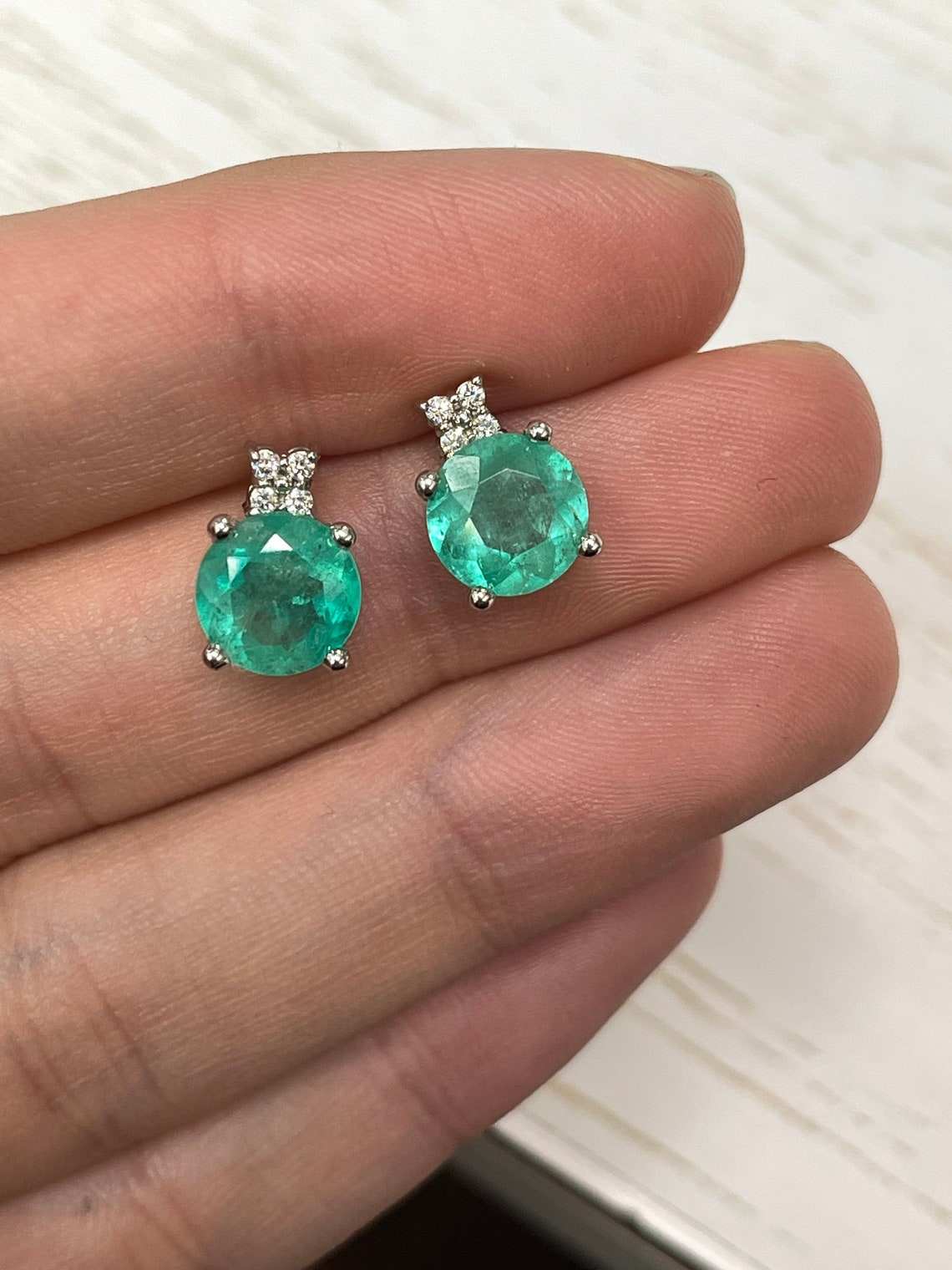 JR Colombian Emeralds 14K gold stud earrings featuring round blue-green Colombian emeralds and diamond accents, stacked design.