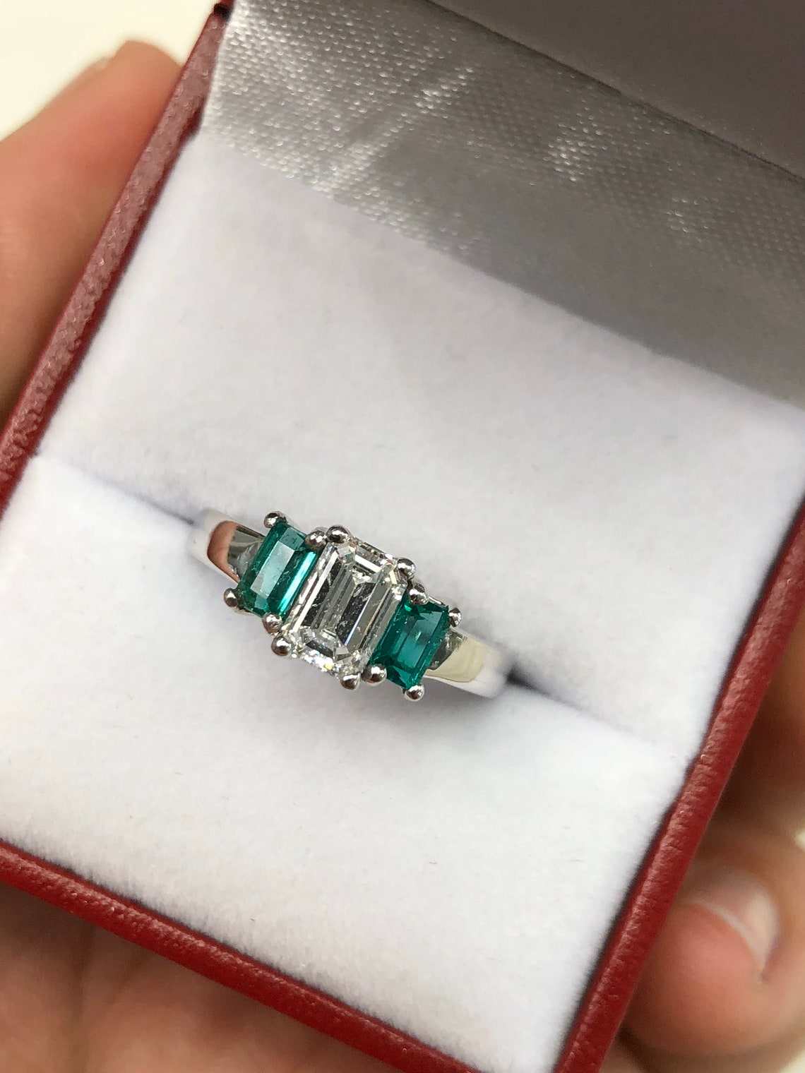 Three-stone diamond and emerald engagement ring in 14K gold from JR Colombian Emeralds, showcasing elegant sparkle and vibrant gemstones.