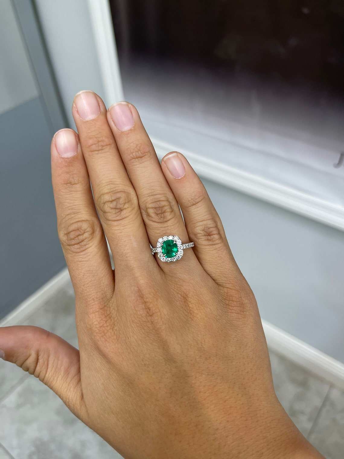 Natural emerald and diamond halo engagement ring in 14K gold with detailed gemstone settings, from JR Colombian Emeralds.