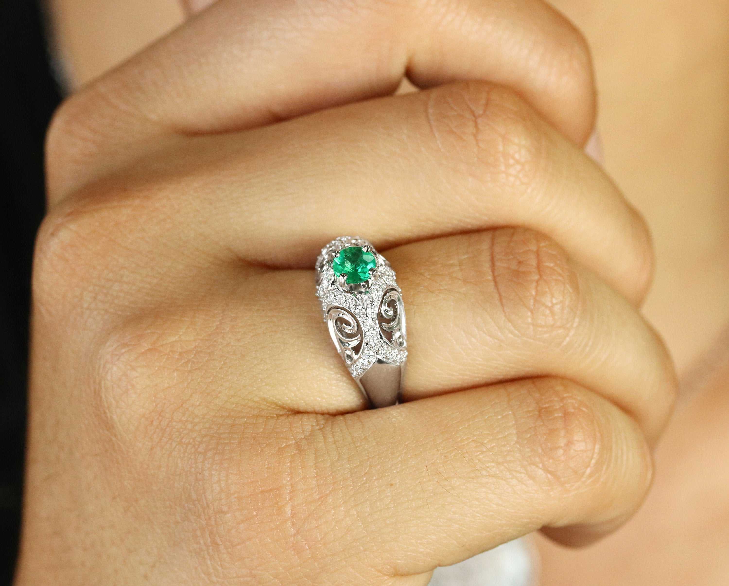 Ladies 14K gold emerald engagement ring with 0.83tcw natural emerald, halo of pave diamonds, and round diamond accents.