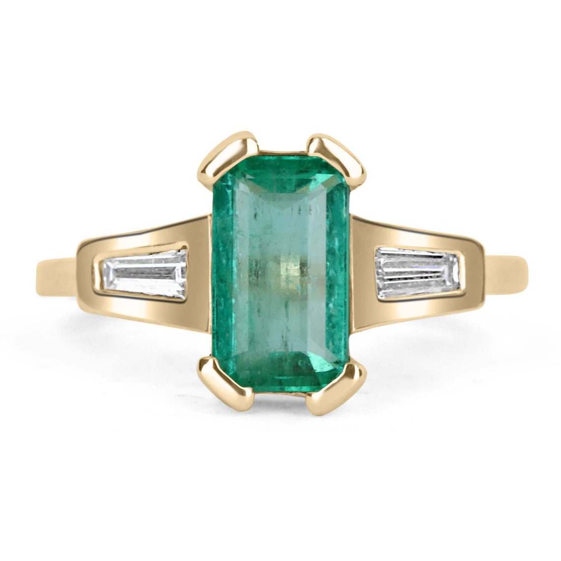 Ladies emerald ring featuring a 2.15tcw emerald-cut Colombian emerald and tapered baguette diamonds in 14K gold.